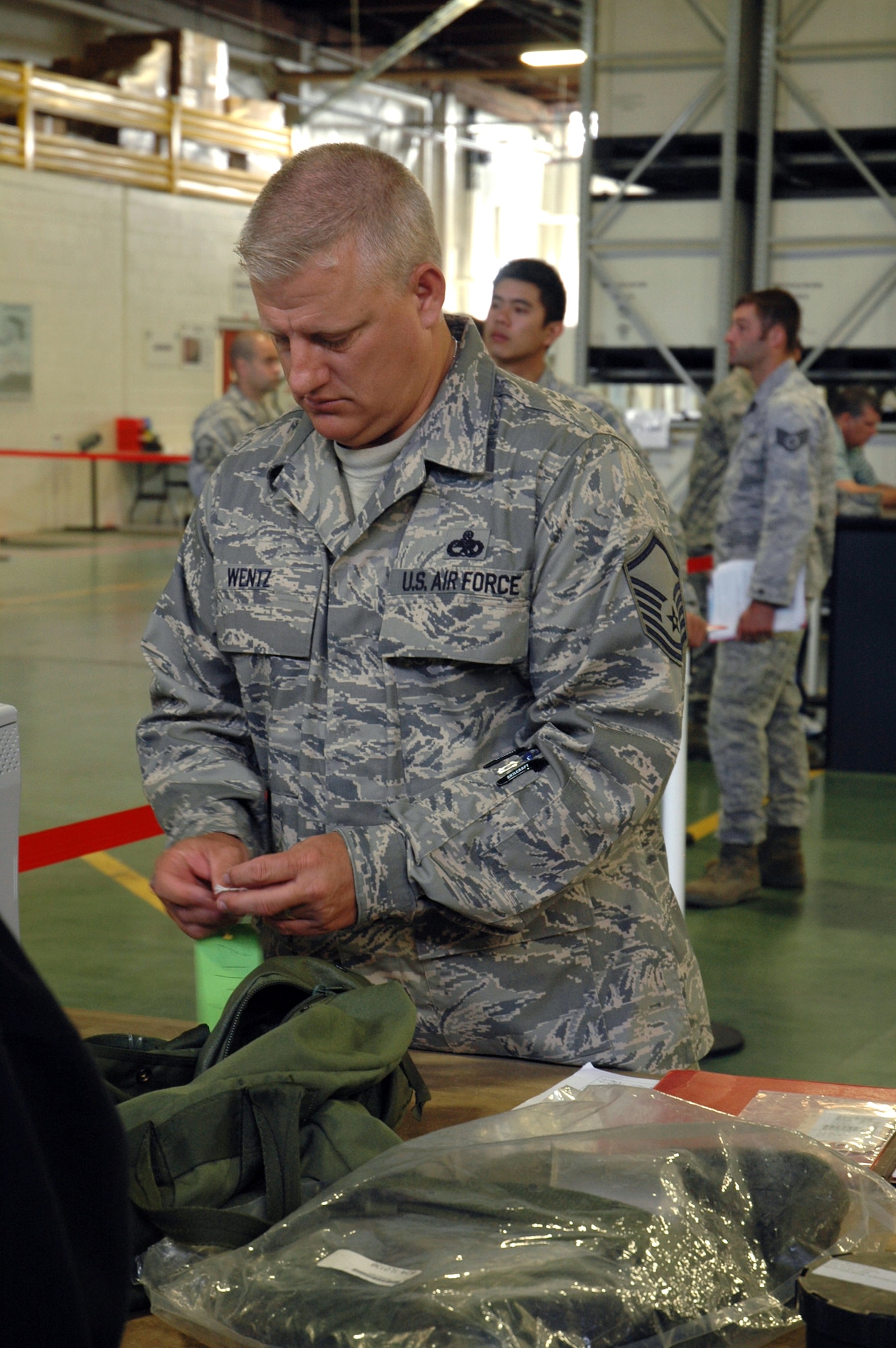 Master Sgt. Randall Wentz, 446th Aircraft Maintenance Squadron, looks over his equipment as he moves through the final stop on the deployment processing line June 29 at Joint Base Lewis-McChord, McChord Field, Wash. Sergeant Wentz will serve as the maintenance production superintendent with the 386th Air Expeditionary Wing in Southwest Asia when he and 26 other Reserve maintenance Airmen deploy in July. (U.S. Air Force photo/Sandra Pishner)