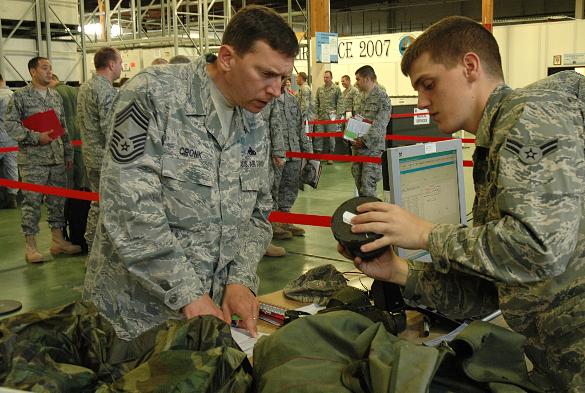 Airman First Class Edward Brie, 62nd Logistics Readiness Squadron, reviews the inventory of equipment Chief Master Sgt. Herbert Cronk, 446th Maintenance Squadron, (left), will be taking with him on his deployment to Southwest Asia in July. Chief Cronk and 26 other Reserve maintenance Airmen went through the deployment processing line June 29 at Joint Base Lewis-McChord, McChord Field, Wash., in preparation for their upcoming 60-day deployment. (U.S. Air Force photo/Sandra Pishner)