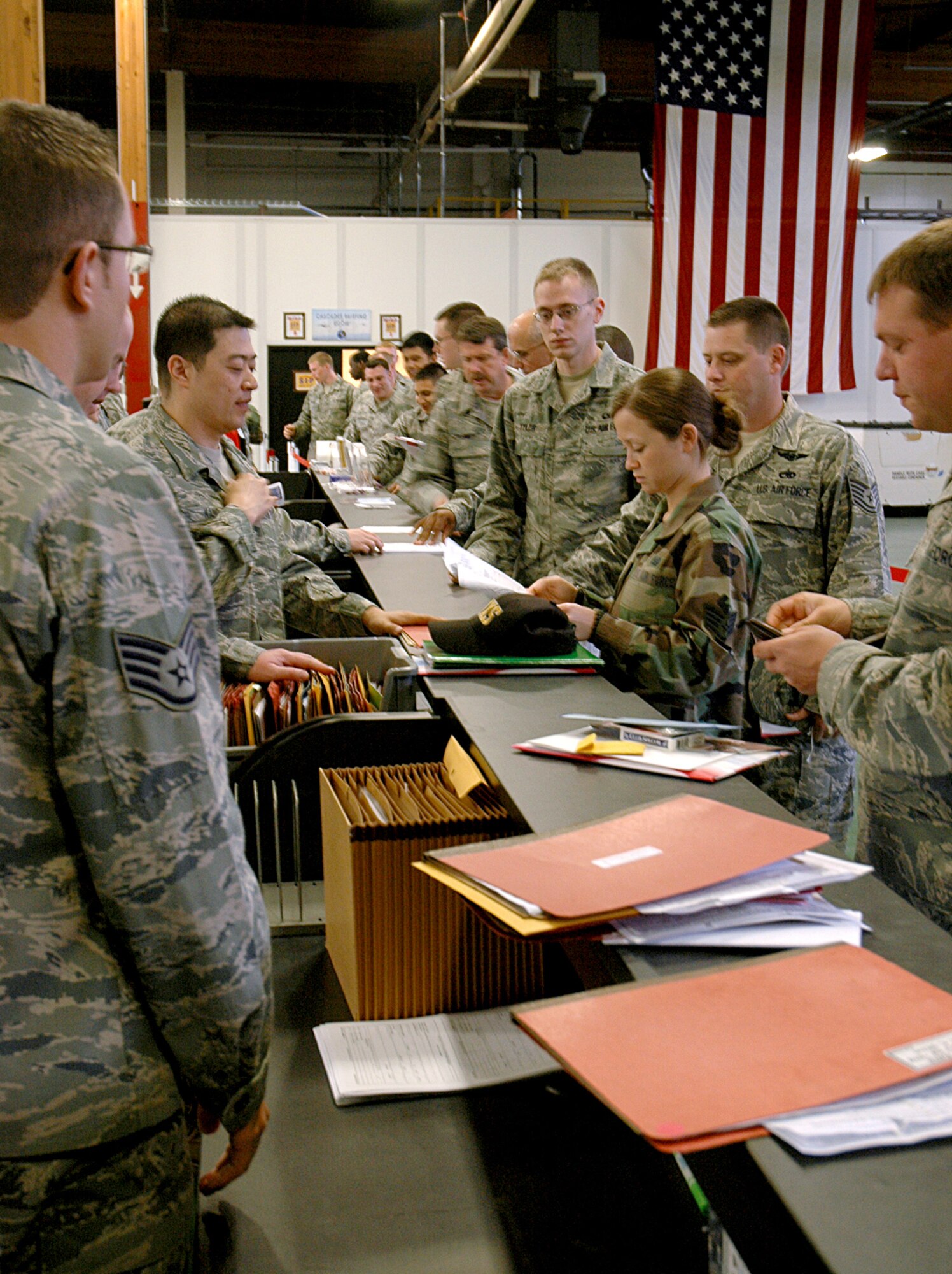 Staff Sgt. Kim Shadlow, 446th Aircraft Maintenance Squadron, (second from right), moves through the deployment processing line June 29 at Joint Base Lewis-McChord, McChord Field, Wash.  Sergeant Shadlow, along with 26 other Reserve maintenance Airmen, will deploy in July to Southwest Asia. (U.S. Air Force photo/Sandra Pishner)
