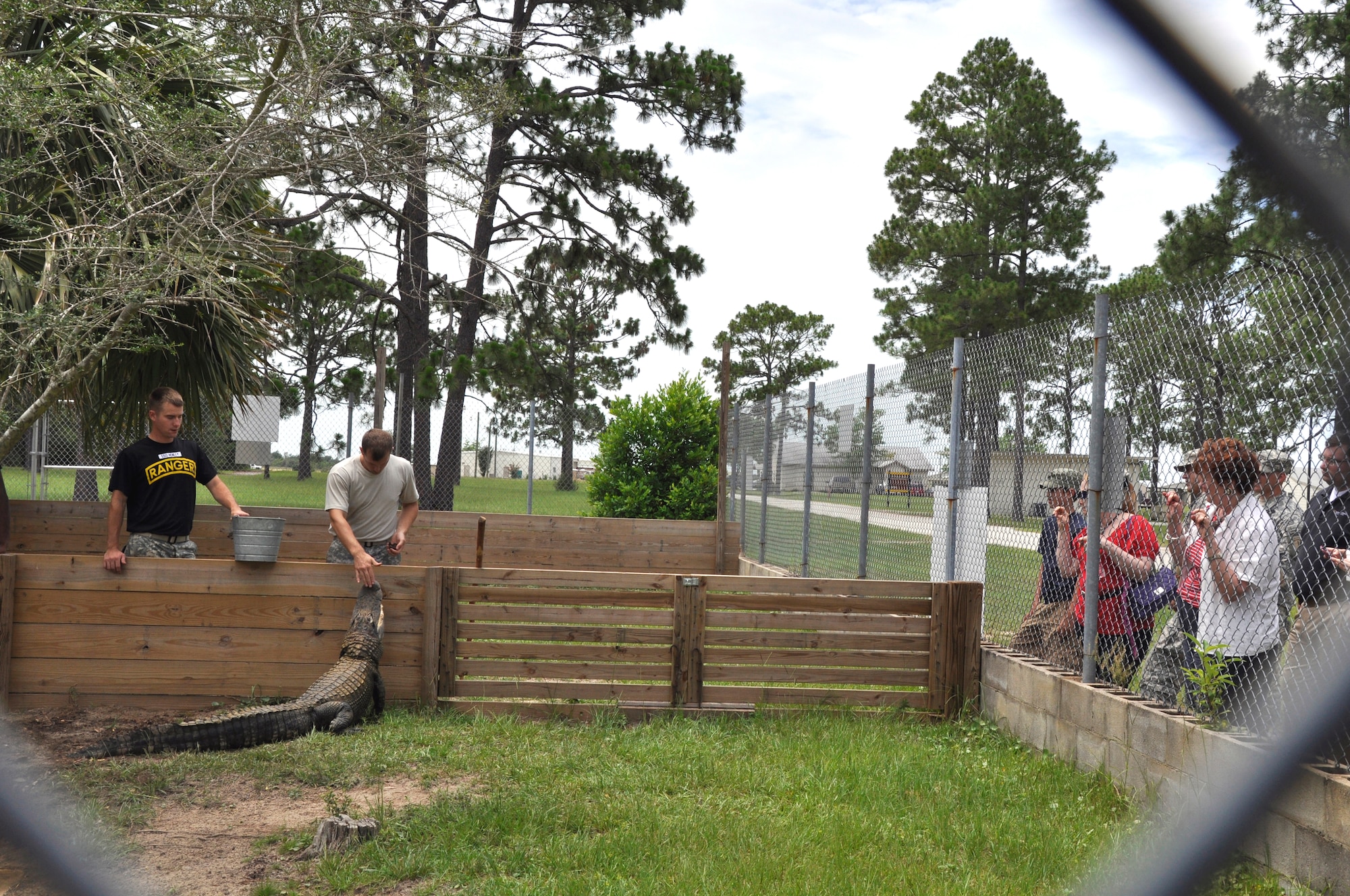 Army Staff Sgts. Heath Henley and Anthony Johnson, 6th Ranger Training Battalion Reptile Team, introduce Stumpy, a female American alligator, to the Team Eglin Honorary Commanders at their quarterly visit to Team Eglin. Stumpy got that particular nickname because her foot was bitten off by a larger, more aggressive alligator.   The Honorary Commanders got the chance to visit the 6th Ranger Training Battalion at Fort Rudder June 29 as part of the program's quarterly tour. The program was created to establish and maintain positive relations with civilian counterparts as well as civic and business leaders. It also allows the general public to experience the mission by spending time with their military counterpart to observe their duties and on base operations. The experience the honorary commanders come away with was an inside look at the role Eglin plays in supporting the Air Force mission and national defense.(U.S. Air Force photo/Errica Bennett)