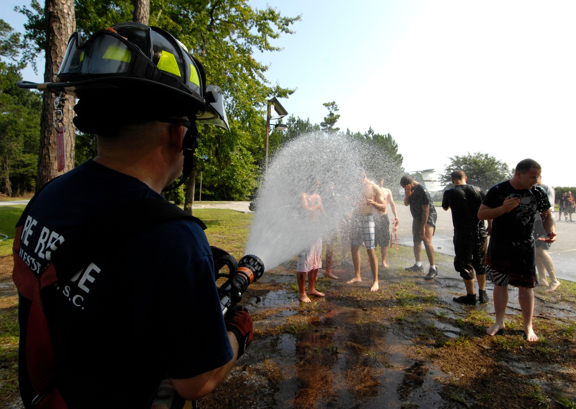 Jeff Feltner hoses down members of Joint Team Charleston during a mass decontamination following a simulated bomb explosion on Joint Base Charleston, S.C., June 25, 2010. Explosive Ordnance Disposal assisted with the simulated explosion by setting off a block of C-4 at the explosives range. Security forces, the fire department and medical personnel responded immediately to gain control of the situation. Mr. Feltner is a fire captain with the 628th Civil Engineer Squadron. (U.S. Air Force Photo/Airman 1st Class Lauren Main)