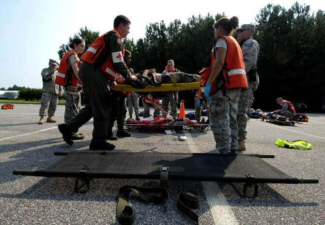 Airmen from the 628th Medical Group transport a casualty to an ambulance to receive further medical attention during a mass casualty exercise on Joint Base Charleston, S.C., June 25, 2010. Responders to the simulated incident included the 628th Civil Engineer Squadron to eliminate fires caused by the explosion and to dispose of any additional explosive material. The 628th Security Forces Squadron set up a cordon, secured the area, and the 628th Medical Group provided emergency medical attention to victims. (U.S. Air Force Photo/Airman 1st Class Lauren Main)