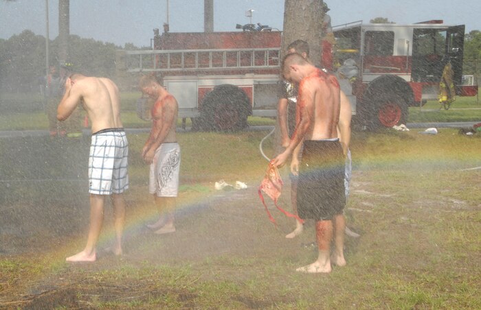 Airmen and Sailors from Joint Base Charleston, S.C., are hosed down for mass decontamination during an exercise which simulated the explosion of a bomb June 25, 2010. The initial mass decontamination washes away any chemicals or toxins which victims have been exposed to in the event of a real chemical attack. (U.S. Air Force Photo/Airman 1st Class Lauren Main)