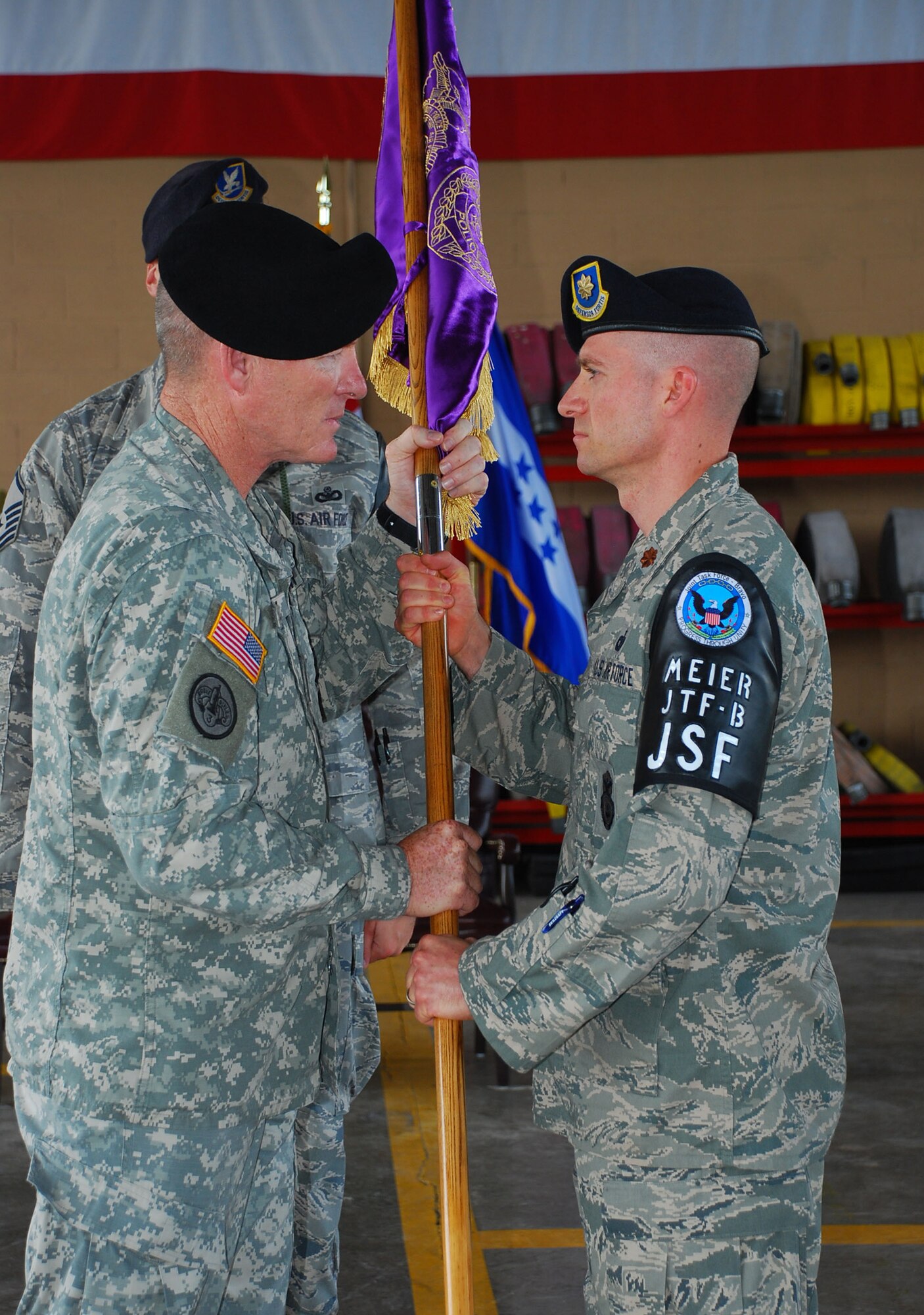 SOTO CANO AIR BASE, Republic of Honduras --  Col. Gregory Reilly, the Joint Task Force Bravo commander, passes the guidon to Maj. James Meier at a change of command ceremony here for the Joint Security Forces here June 29. The passing of the colors to represent the change of command is a tradition that dates back to the 17th century. (U.S. Air Force photo/Martin Chahin)
