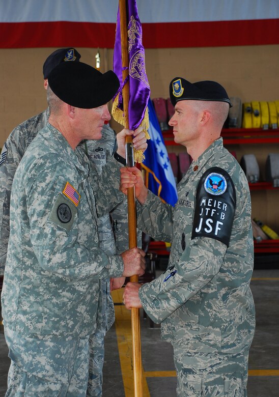 SOTO CANO AIR BASE, Republic of Honduras --  Col. Gregory Reilly, the Joint Task Force Bravo commander, passes the guidon to Maj. James Meier at a change of command ceremony here for the Joint Security Forces here June 29. The passing of the colors to represent the change of command is a tradition that dates back to the 17th century. (U.S. Air Force photo/Martin Chahin)