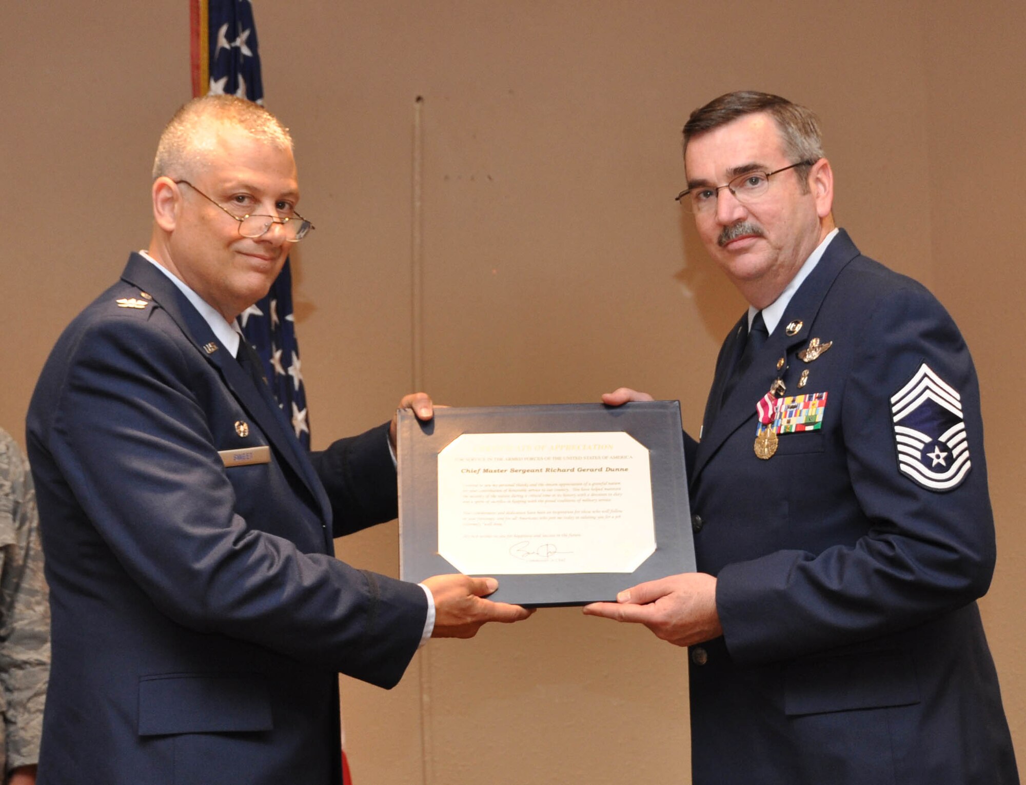Col. Philip Sweet, 934th Aeromedical Staging Squadron commander, presents Chief Master Sgt. Richard Dunne with a certificate of appreciation at his retirement ceremony June 5. (Air Force photo/Master Sgt. Kerry Bartlett)