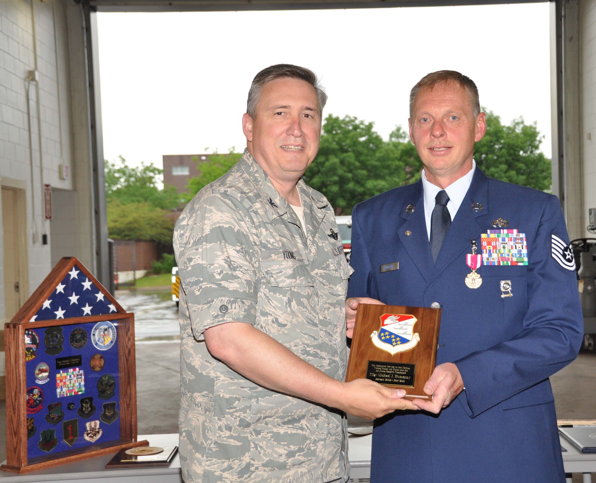 Tech. Sgt. Michael Humenny, a Purple Heart recipient, receives his retirement plaque from Col. Darrell Young June 5.
(Air Force photo/Senior Airman Noah Johnson)
