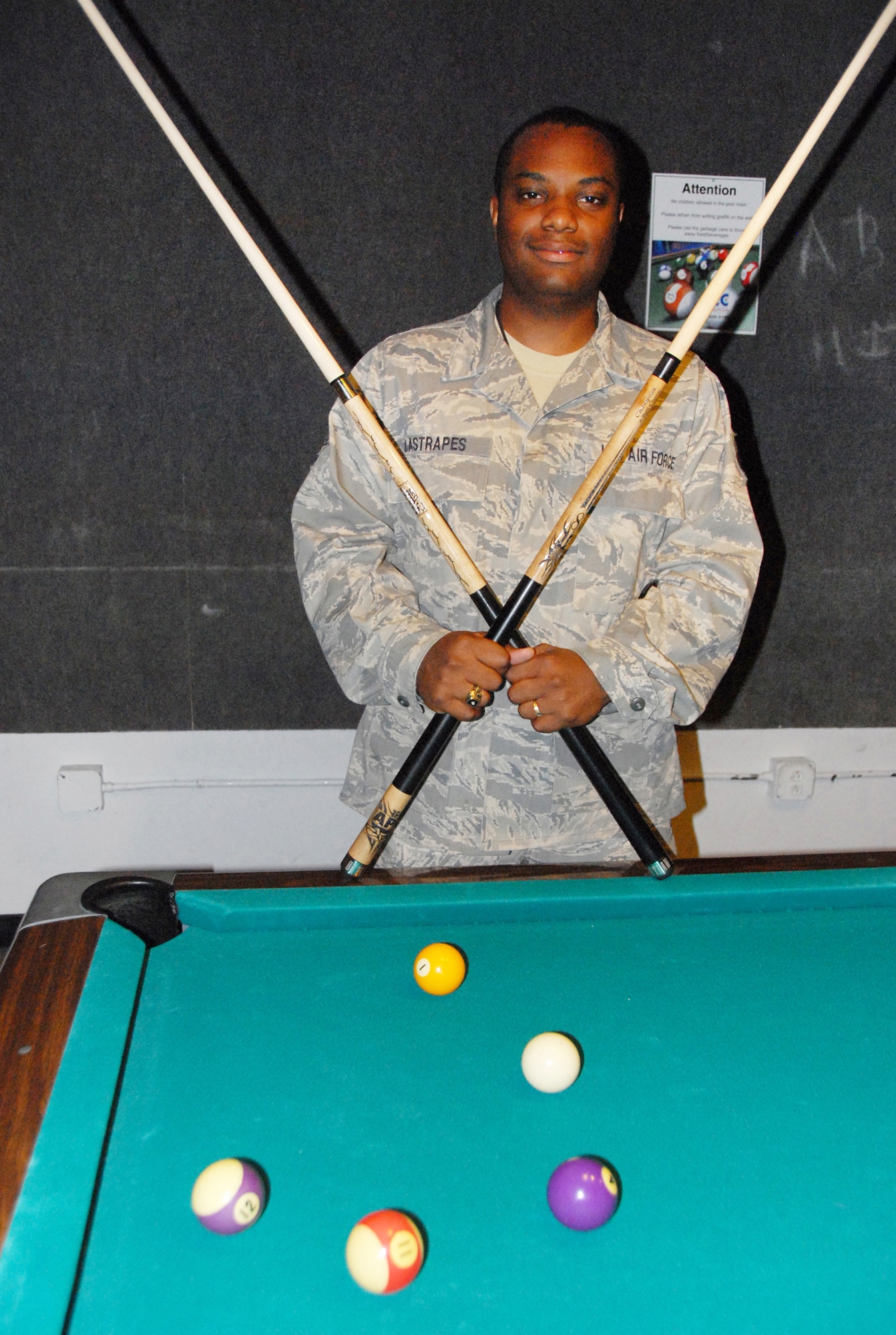 Senior Airman Davis Lastrapes holds the two pool sticks he won in American Poolplayers Association National Championship. U. S. Air Force photo by Wayne Crenshaw