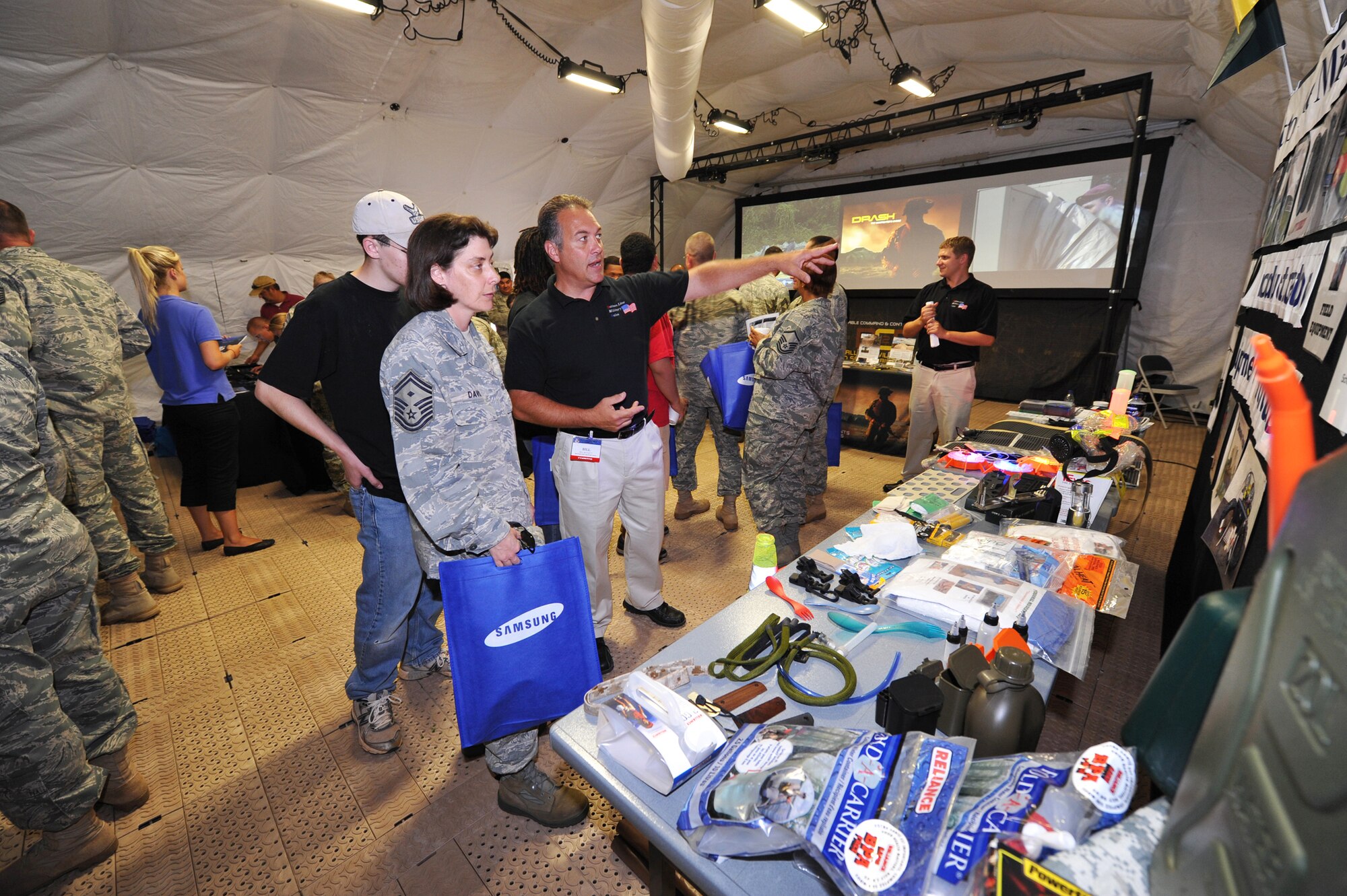 Bill Beckett, Bottom Line Military Sales, shows Senior Master Sgt. Grace Davis, 52nd Combat Communications Squadron, some of his company's wares. U. S. Air Force photo by Gary Cutrell