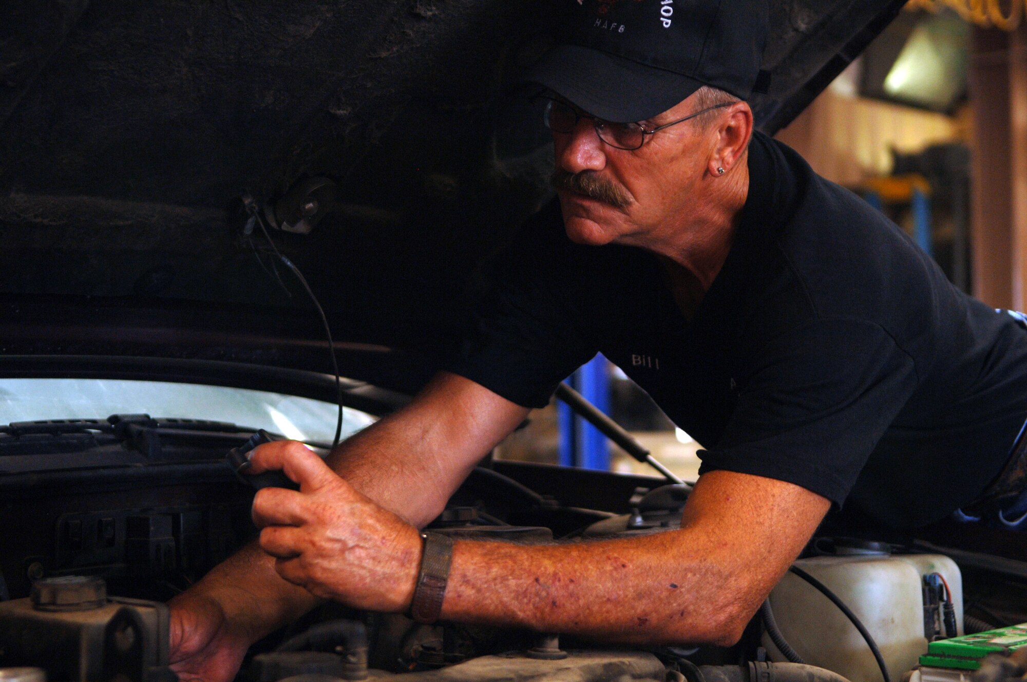 HOLLOMAN AIR FORCE BASE, N.M. -- Bill Wade, a mechanic at the Auto Hobby Shop, works under the hood of a car June 25, 2010. The shop opens its doors six days a week, with Mondays being open for appointments only, and is open to anyone with base access. (U.S. Air Force photo by Airman 1st Class Siuta Ika / Released)