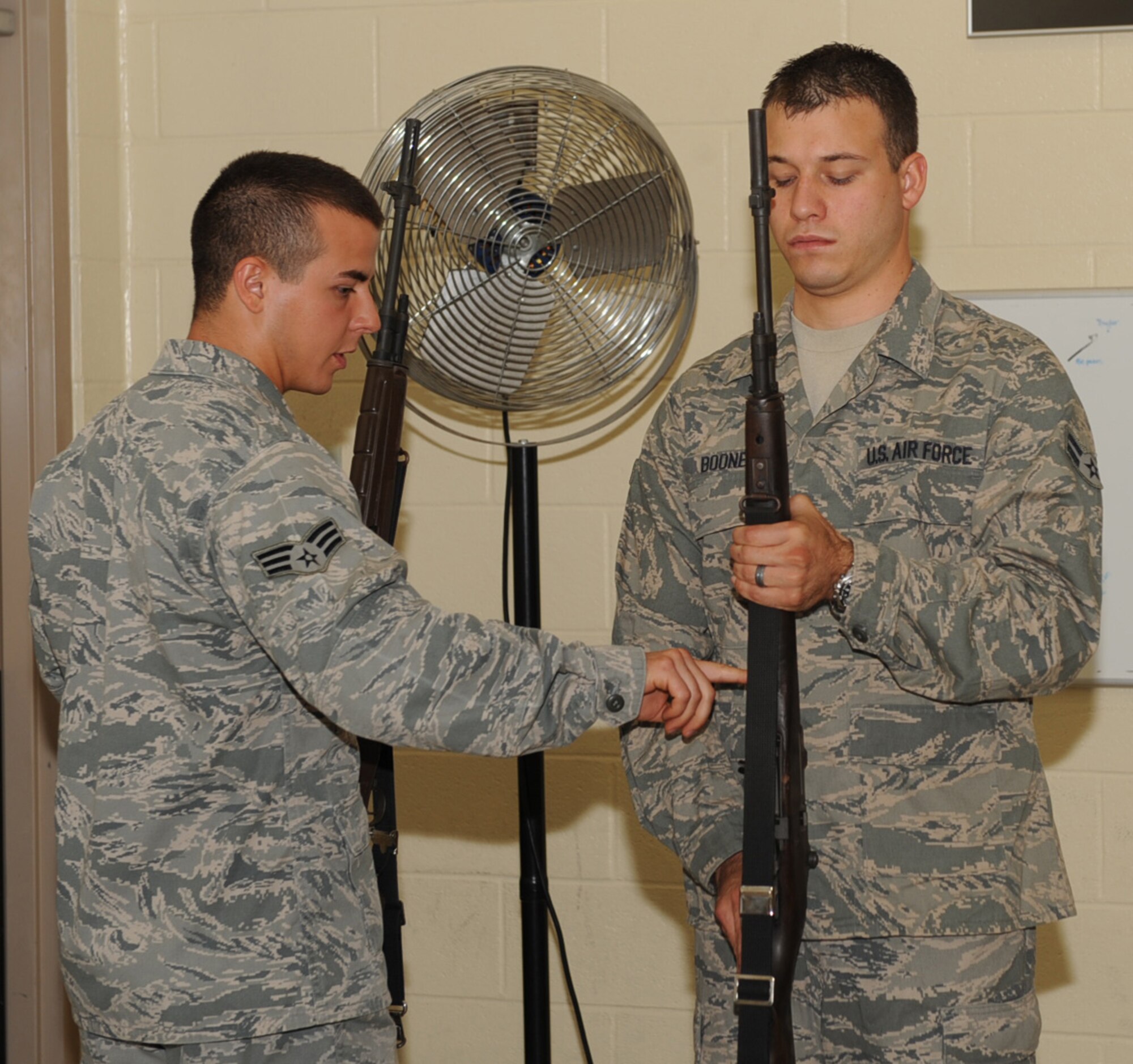 SEYMOUR JOHNSON AIR FORCE BASE, N.C. -- Senior Airman Michael Stevens instructs Airman 1st Class James Boone how to properly hold a rifle here June 29, 2010. The training provides Airman Boone with skills to perform as a member of the base Honor Guard firing squad. Airman Stevens, 4th Aircraft Maintenance Squadron avionics technician, hails from Gary, Ind. Airman Boone, 4th Aerospace Medicine Squadron bioenvironmental technician, is a native of Owensville, Mo. (U.S. Air Force photo/Senior Airman Gino Reyes)