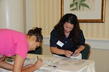 Tech. Sgt. Cynthia A. Flaherty (right), Personnel Employment Office, Pope Air Force Base, assists a family member with registering for the Yellow Ribbon program at the Ballantyne in June. (USAF photo by SSgt. Terrica Jones, 916ARW/PA)