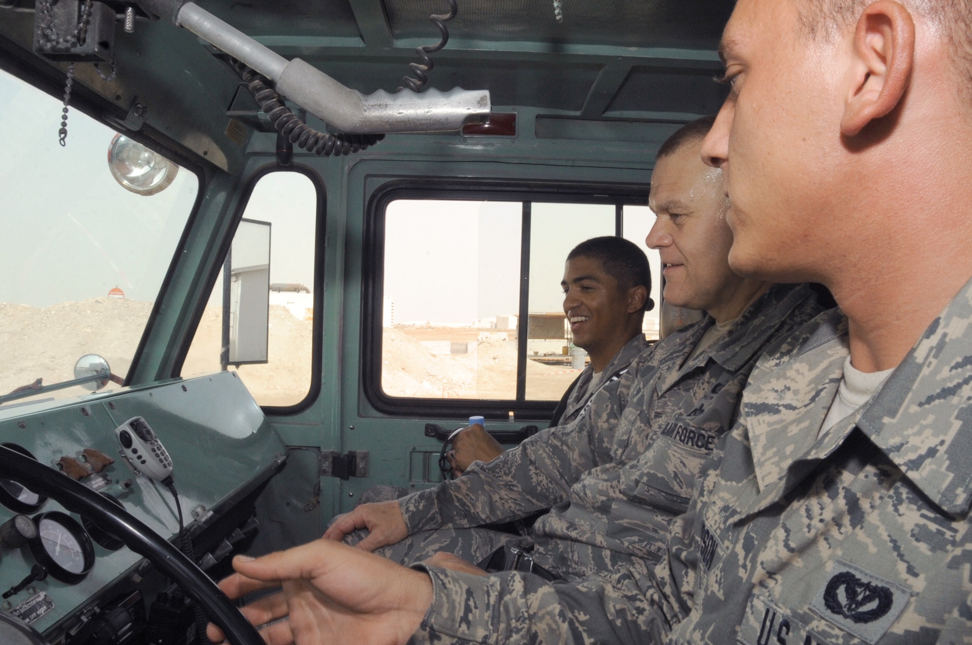 Senior Airman Joshua Thompson explains the operation of a P-19 crash fire truck to Chief Master Sgt. of the Air Force James A. Roy and Staff Sgt. Delavar McKee June 27, 2010, at a base in Southwest Asia. Airman Thompson is a firefighter driver operator with the 380th Expeditionary Civil Engineer Squadron. (U.S. Air Force photo/Tech. Sgt. April Wickes)