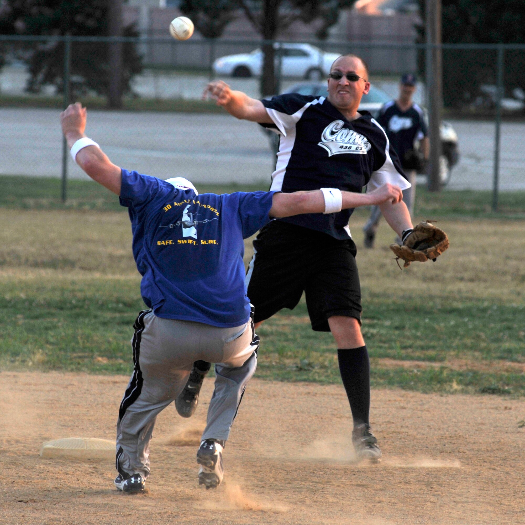 Josh Solomon, 436th Communications Squadron second baseman/coach, attempts to turn a double play during a National League softball game at the Dover Air Force Base softball field June 29, 2010. Comm defeated the 3rd Airlift Squadron 14-4. (U.S. Air Force photo by Tech. Sgt. Chuck Walker/Released)