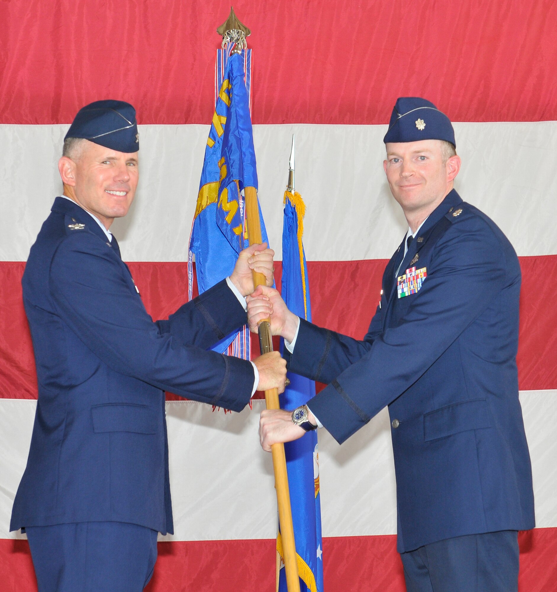Lieutenant Col. Michael Ingersoll accepts the 325th Aircraft Maintenance Squadron guidon from Col. Craig Hall, 325th Maintenance Group commander, during a Change of Command ceremony June 25 at Tyndall.  Colonel Ingersoll replaces Lt. Col. Paul Kanning as the new 325th AMXS commander.  (U.S. Air Force photo by Lisa Norman)
