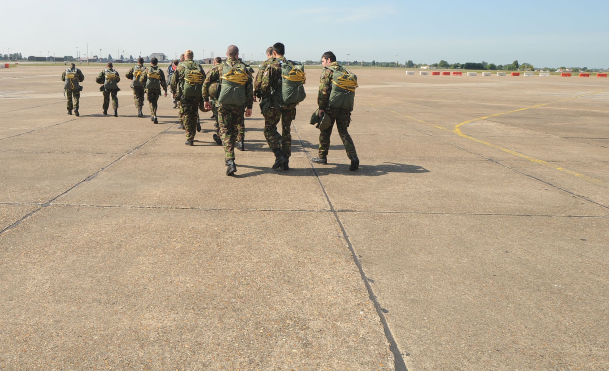 British military members from the 23 Engineer Regiment head out onto the flightline at RAF Mildenhall June 22, to await the arrival of an MC-130H. They were here working with the U.S. Air Force, to earn their American jump wings, and used parachutes belonging to the 321st Special Tactics Squadron. The British regiment jumped with personnel from the 7th Special Operations Squadron, and in return, members from RAF Mildenhall got to jump from a British aircraft June 24. (U.S. Air Force photo/Karen Abeyasekere)