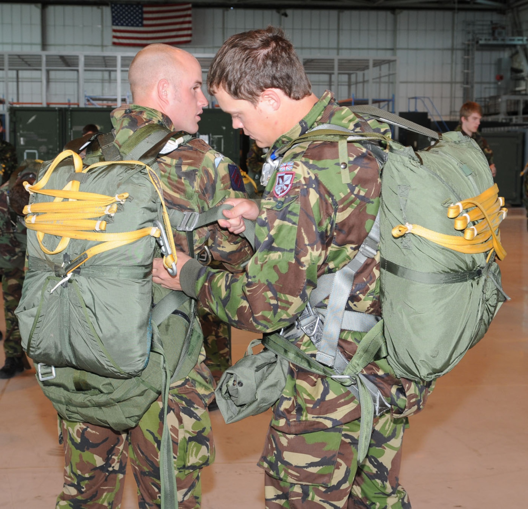 Corporal Phil Askey, left, has his straps checked by Lance Corporal Josh Boggi, both 9 Parachute Squadron, 23 Engineer Regiment, Woodbridge, after fitting a parachute. The British military members were at RAF Mildenhall to take part in a parachute jump from a U.S. Air Force MC-130H to earn their American jump wings. They jumped with members from the 7th Special Operations Squadron using parachutes belonging to the 321st Special Tactics Squadron. (U.S. Air Force photos/Karen Abeyasekere)