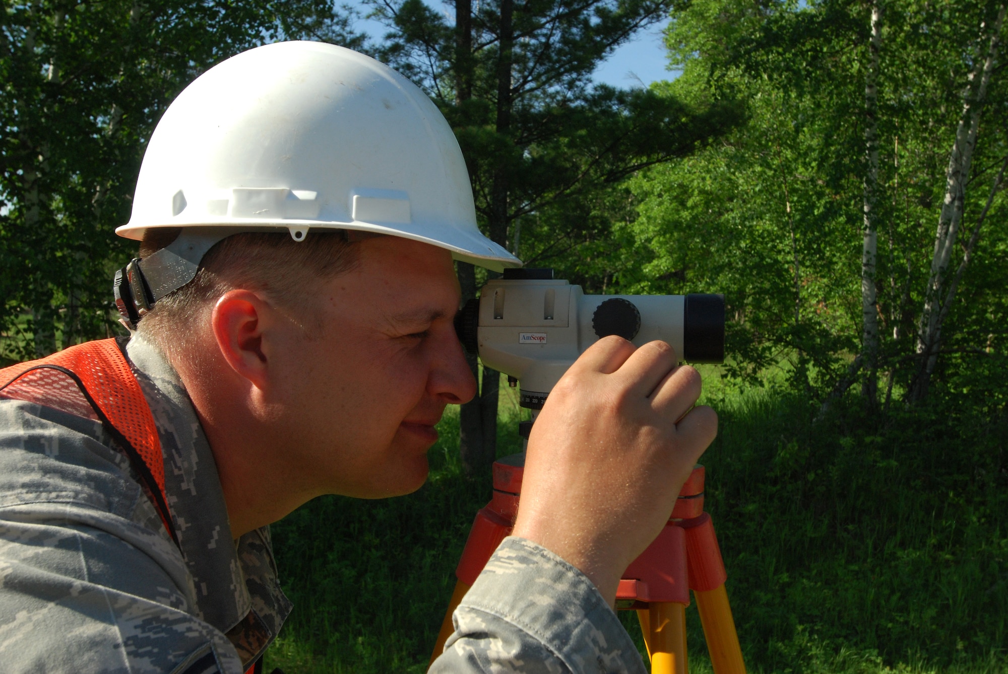 Members of the 433rd Civil Engineering Squadron conduct a humanitarian mission in the Red Lake Indian Reservation for the Red Lake band of Chippewa Indians, just outside of Bemidji, Minnesota. Staff Sgt. Chris Gregory, 433rd CES, shoots grade to make sure the 12-inch water pipe in a 10-foot deep ditch next to him is at the proper depth. (U.S. Air Force photo/Airman 1st Class Brian McGloin)