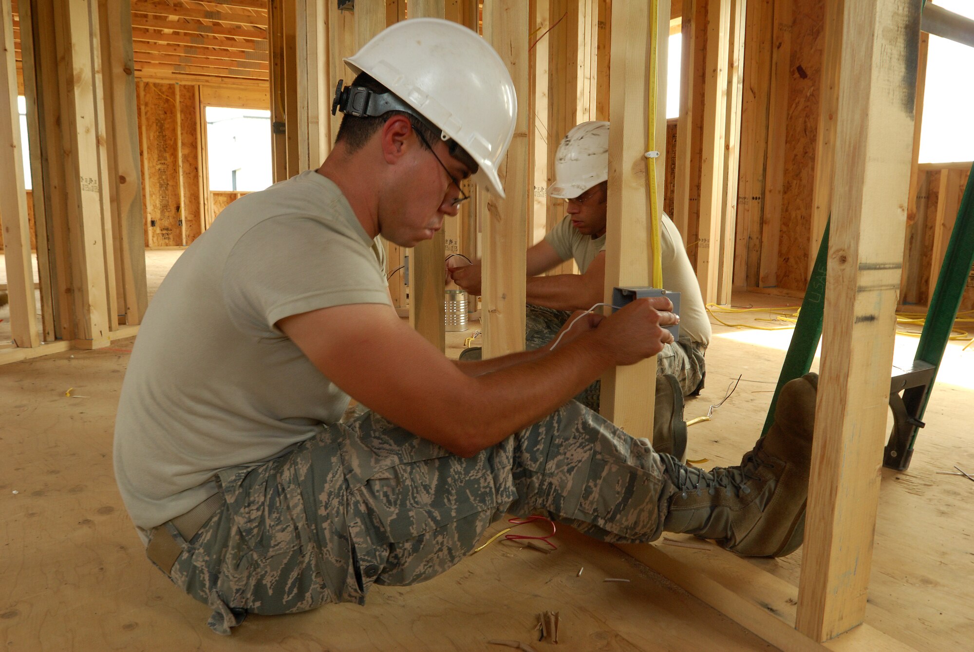 Members of the 433rd Civil Engineering Squadron conduct a humanitarian mission in the Red Lake Indian Reservation for the Red Lake band of Chippewa Indians, just outside of Bemidji, Minnesota. Senior Airman Jaime Payen and Staff Sgt. David Bustos wire boxes which will hold electrical outlets in what will be two separate bedrooms.(U.S. Air Force photo/Airman 1st Class Brian McGloin)