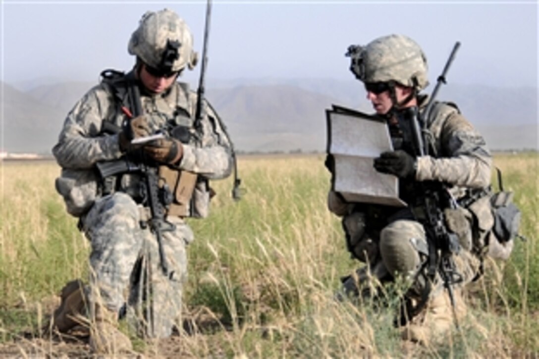 U.S. Army 1st Lt. Matthew Hilderbrand, left, writes down grid coordiantes off a map from Staff Sgt. Kevin Sentieri, right, during a break while patroling across a plateau in search of a weapons cache outside Combat Outpost Sangar in Zabul province, Afghanistan, June 27, 2010. Hilderbrand and Sentieri are assigned to Company D, 1st Battalion, 4th Infantry Regiment, U.S. Army Europe.