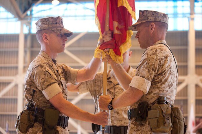 Col. Michael A. O’Halloran (right) passes the organizational colors to Col. James C. Stewart during the Marine Corps Air Station Iwakuni change-of-command ceremony here June 30. The exchange of the organizational colors is symbolic of the transfer of command from the outgoing commanding officer to the oncoming commanding officer.