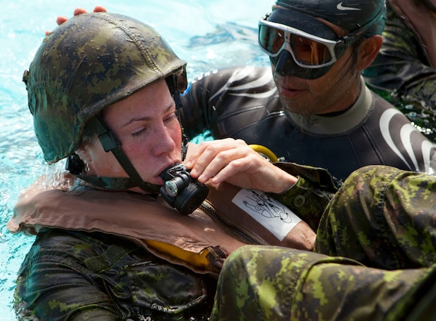 Cpl. Stacey Cripps, a medical technician assigned to Company G, 2nd Battalion, The Royal Canadian Regiment, Canadian Forces, learns how to breathe through a respirator under the guidance of Water Survival Systems USA instructor Lesa Maiava at the base pool on Marine Corps Base Hawaii June 30. Cripps and fellow 2nd RCR soldiers participated in training with Marines from 2nd Battalion, 3rd Marine Regiment, as part of the Exercise Rim of the Pacific 2010, a biennial exercise designed to strengthen regional partnerships and improve bilateral interoperability.
