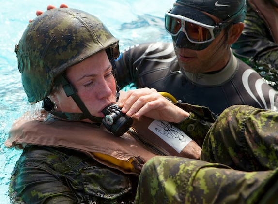 Cpl. Stacey Cripps, a medical technician assigned to Company G, 2nd Battalion, The Royal Canadian Regiment, Canadian Forces, learns how to breathe through a respirator under the guidance of Water Survival Systems USA instructor Lesa Maiava at the base pool on Marine Corps Base Hawaii June 30. Cripps and fellow 2nd RCR soldiers participated in training with Marines from 2nd Battalion, 3rd Marine Regiment, as part of the Exercise Rim of the Pacific 2010, a biennial exercise designed to strengthen regional partnerships and improve bilateral interoperability.