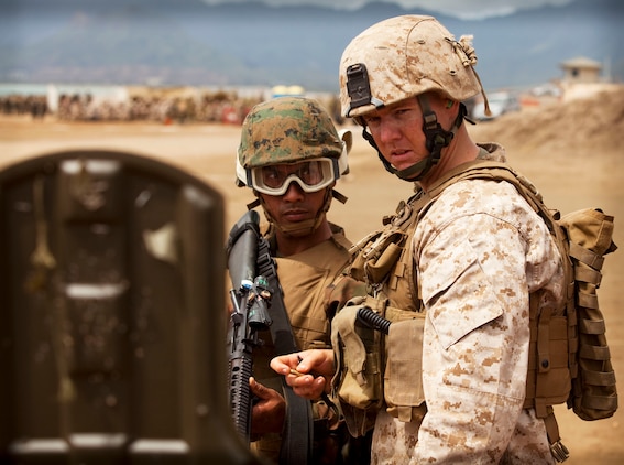 Cpl. Dave Spraker, a team leader with 3rd platoon, Company E, 2nd Battalion, 3rd Marine Regiment, examines the shot group of a Royal Tongan Marine during a battle sight zero exercise at the Marine Corps Base Hawaii Range Training Facility June 30. Service members from Australia, Canada, Indonesia, Malaysia and Tonga joined the 2/3 Marines in training as part of the Exercise Rim of the Pacific 2010, a biennial exercise designed to strengthen regional partnerships and improve bilateral interoperability.