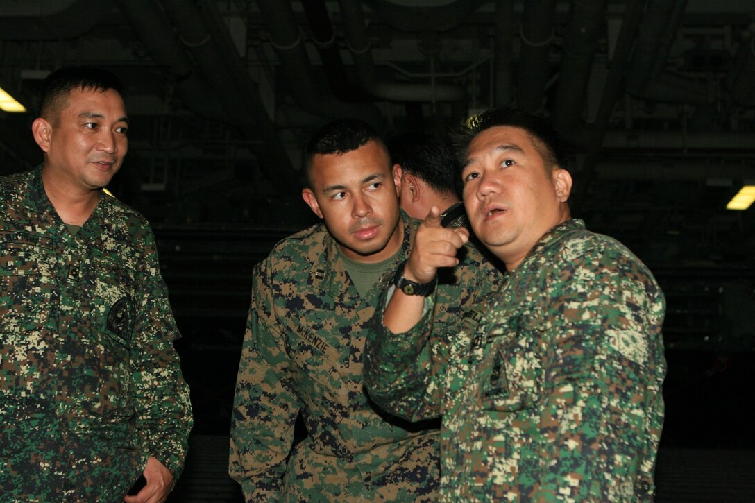 Maj. Niel Estrella, a civil military operations officer with the Philippine Marines Corps, and Capt. Richard McKenzie, an assistant operations officer with Battalion Landing Team 2nd Battalion, 7th Marines (BLT 2/7), 31st Marine Expeditionary Unit (MEU), discuss information about a landing craft unit (LCU), in the well deck aboard the forward-deployed amphibious assault ship USS Essex (LHD 2), March 1. The MEU recently completed Exercise Cobra Gold 2010 (CG ’10) and is currently scheduled to go underway to the Republic of the Philippines in support of Exercise Balikatan 2010 (BK ’10). (Official Marine Corps photo by Lance Cpl. Dengrier M. Baez)