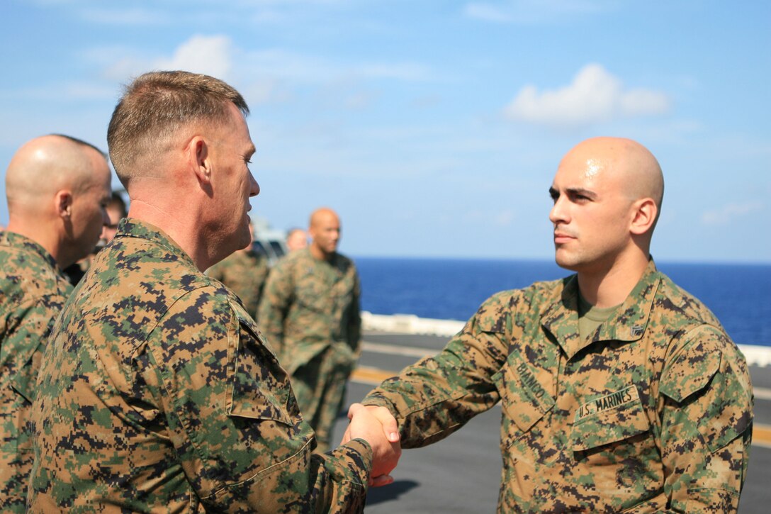 Cpl. Michael A. Bianco, a combat correspondent with the 31st Marine Expeditionary Unit (MEU), shakes hands with Col. Paul L. Damren, 31st MEU Commanding Officer, after being promoted to his current rank during a promotion ceremony aboard the forward-deployed amphibious assault ship USS Essex (LHD 2), March 1. The MEU recently completed Exercise Cobra Gold 2010 (CG ’10) and is currently underway to the Republic of the Philippines in support of Exercise Balikatan 2010 (BK ’10).