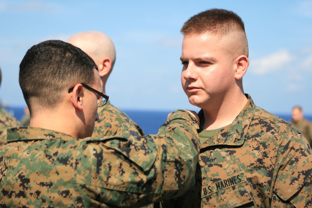 Lance Cpl. Tyler P. Kerber, a data and network specialist with the 31st Marine Expeditionary Unit (MEU), is pin to his current rank by Lance Cpl. James Marquez, a 31st MEU data and network specialist, aboard the flight deck of the forward-deployed amphibious assault ship USS Essex (LHD 2), March 1. The MEU recently completed Exercise Cobra Gold 2010 (CG ’10) and is currently underway to the Republic of the Philippines in support of Exercise Balikatan 2010 (BK ’10).
