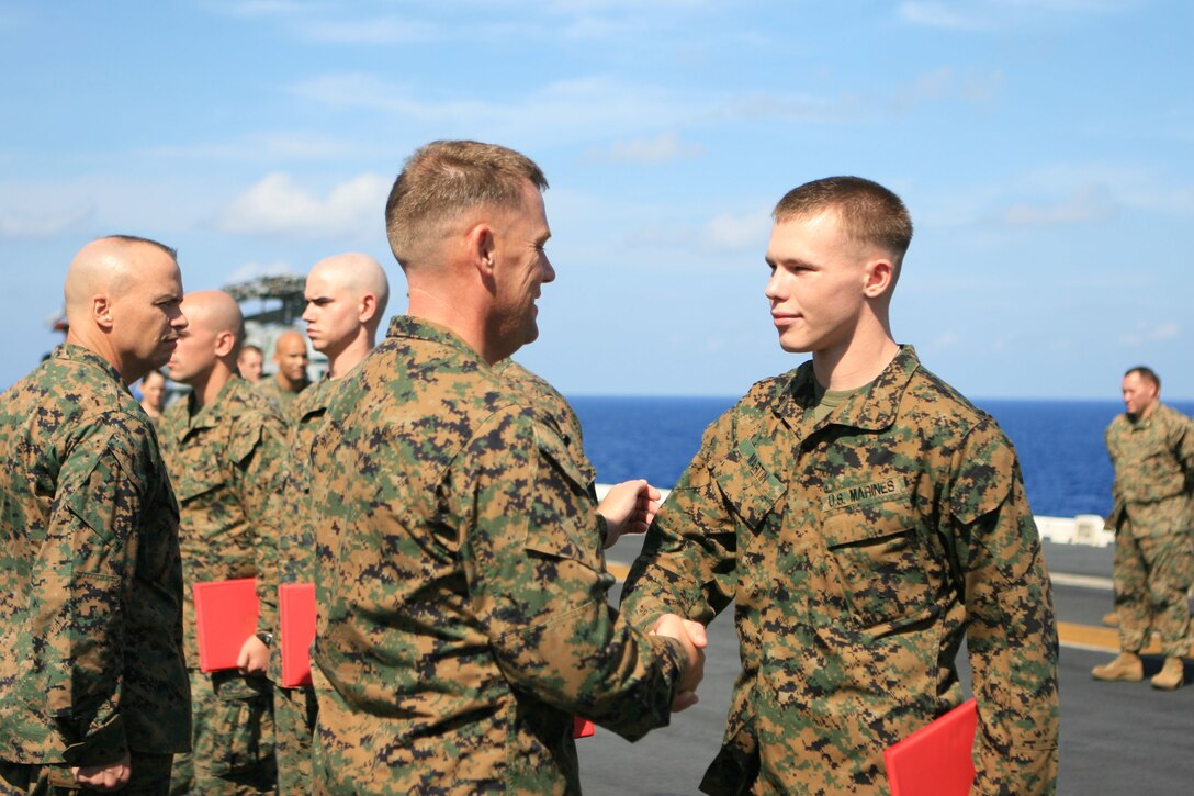 Lance Cpl. Brian J. Martin, a data and network specialist with the 31st Marine Expeditionary Unit (MEU), shakes hands with Col. Paul L. Damren, 31st MEU Commanding Officer, after being promoted to his current rank during a promotion ceremony aboard the flight deck of the forward-deployed amphibious assault ship USS Essex (LHD 2), March 1. The MEU recently completed Exercise Cobra Gold 2010 (CG ’10) and is currently underway to the Republic of the Philippines in support of Exercise Balikatan 2010 (BK ’10).