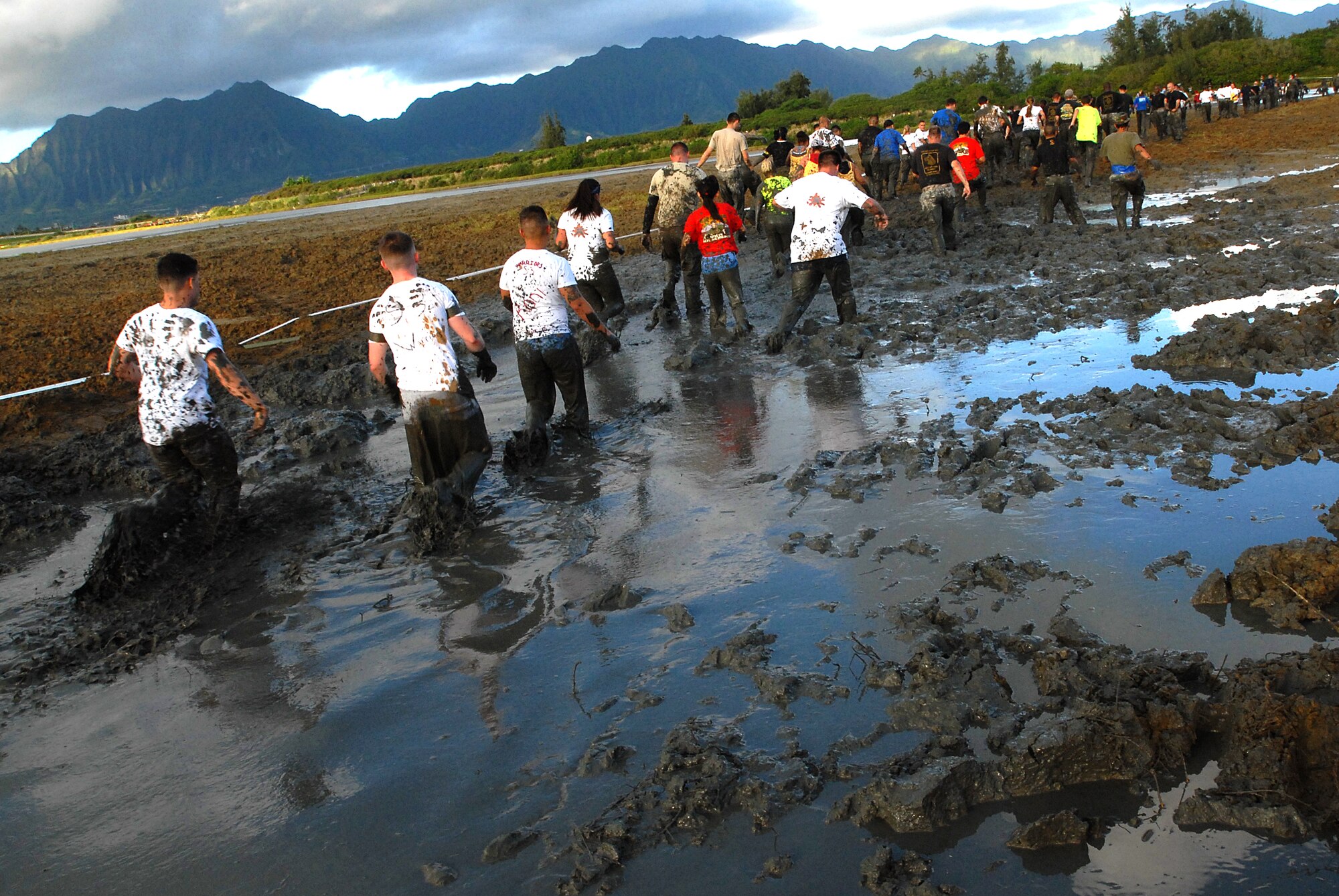 MARINE CORPS BASE HAWAII KANEOHE BAY, Hawaii -- More than 450 six-person teams got down and dirty during the muddiest race of the year at the Marine Corps' 16th Annual Swamp Romp Feb. 20. The Marine Corps Combat Service Support Group 3 and Marine Corps Community Services hosted the five-mile muddy obstacle course known as Oahu's "dirtiest footrace." Some teams dressed for the occasion by putting on their combat boots and strapping them down with duct tape, while others went for a more themed approach. Costumes from jail birds and ninjas to superheroes like Spiderman, Wonder Woman, Super Girl and a group of prom night beauty contestants were not in their best condition at the end of the race. (U.S. Air Force photo/ Staff Sgt. Mike Meares)