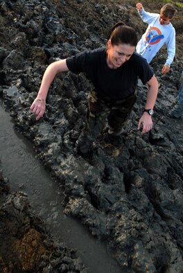 MARINE CORPS BASE HAWAII KANEOHE BAY, Hawaii -- Capt. Sharon Tweedy, 15th Airlift Wing executive officer, sticks her way throug hthe mud during the Marine Corps' 16th Annual Swamp Romp Feb. 20. More than 450 six-person teams got down and dirty during the muddiest race of the year. The Marine Corps Combat Service Support Group 3 and Marine Corps Community Services hosted the five-mile muddy obstacle course known as Oahu's "dirtiest footrace." Some teams dressed for the occasion by putting on their combat boots and strapping them down with duct tape, while others went for a more themed approach. Costumes from jail birds and ninjas to superheroes like Spiderman, Wonder Woman, Super Girl and a group of prom night beauty contestants were not in their best condition at the end of the race. (U.S. Air Force photo/ Staff Sgt. Mike Meares)