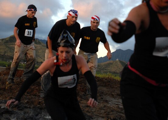 MARINE CORPS BASE HAWAII KANEOHE BAY, Hawaii -- U.S. Air Force Office of Special Investigations team from Hickam wait on participants in the Marine Corps' 16th Annual Swamp Romp Feb. 20. More than 450 six-person teams got down and dirty during the muddiest race of the year. The Marine Corps Combat Service Support Group 3 and Marine Corps Community Services hosted the five-mile muddy obstacle course known as Oahu's "dirtiest footrace." Some teams dressed for the occasion by putting on their combat boots and strapping them down with duct tape, while others went for a more themed approach. Costumes from jail birds and ninjas to superheroes like Spiderman, Wonder Woman, Super Girl and a group of prom night beauty contestants were not in their best condition at the end of the race. (U.S. Air Force photo/ Staff Sgt. Mike Meares)