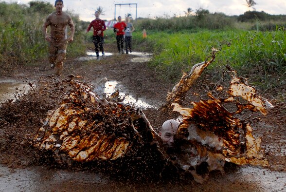 MARINE CORPS BASE HAWAII KANEOHE BAY, Hawaii -- More than 450 six-person teams got down and dirty during the muddiest race of the year at the Marine Corps' 16th Annual Swamp Romp Feb. 20. The Marine Corps Combat Service Support Group 3 and Marine Corps Community Services hosted the five-mile muddy obstacle course known as Oahu's "dirtiest footrace." Some teams dressed for the occasion by putting on their combat boots and strapping them down with duct tape, while others went for a more themed approach. Costumes from jail birds and ninjas to superheroes like Spiderman, Wonder Woman, Super Girl and a group of prom night beauty contestants were not in their best condition at the end of the race. (U.S. Air Force photo/ Staff Sgt. Mike Meares)