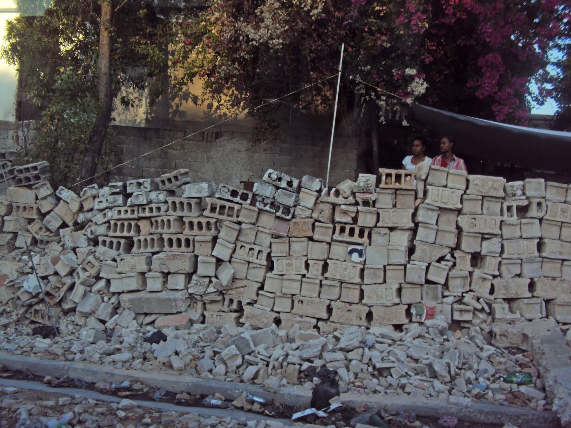 A Haitian family looks over their rebuilt wall, which likely won’t withstand even a small aftershock. (Courtesy photo)