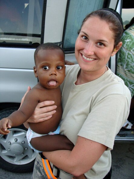 Tech. Sgt. Candace Arbogast, 67th Aerial Port Squadron, entertains a Haitian infant that would soon meet a new family in the U.S. (Courtesy photo)