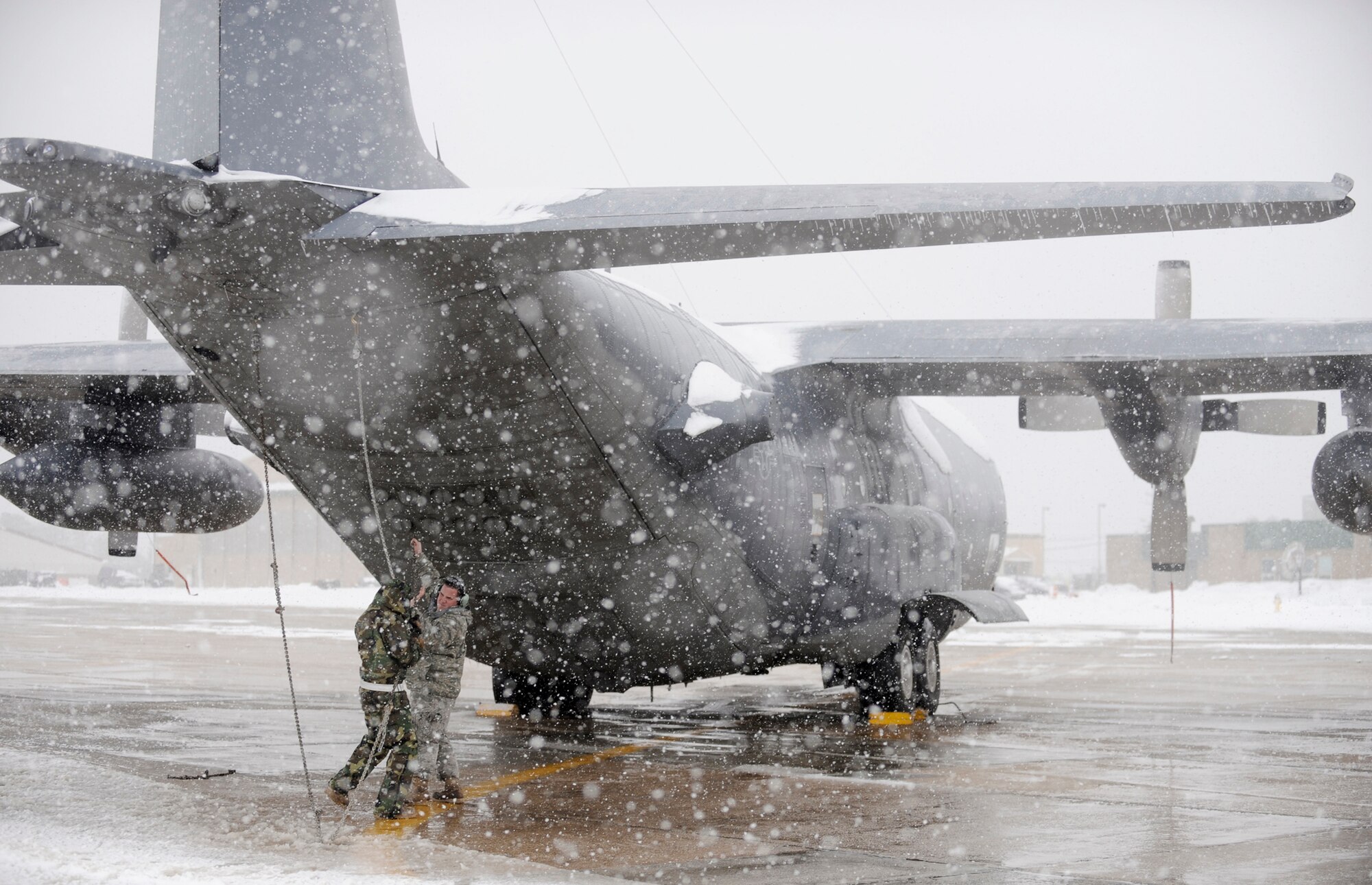 Airmen with the 106th Aircraft Maintenance Squadron work to secure a HC-130 Hercules during a snowstorm at the New York Air National Guard's 106th Rescue Wing at Francis S. Gabreski Airport in Westhampton Beach, N.Y., Feb. 26, 2010. (U.S. Air Force photo/Staff Sgt. David J. Murphy)