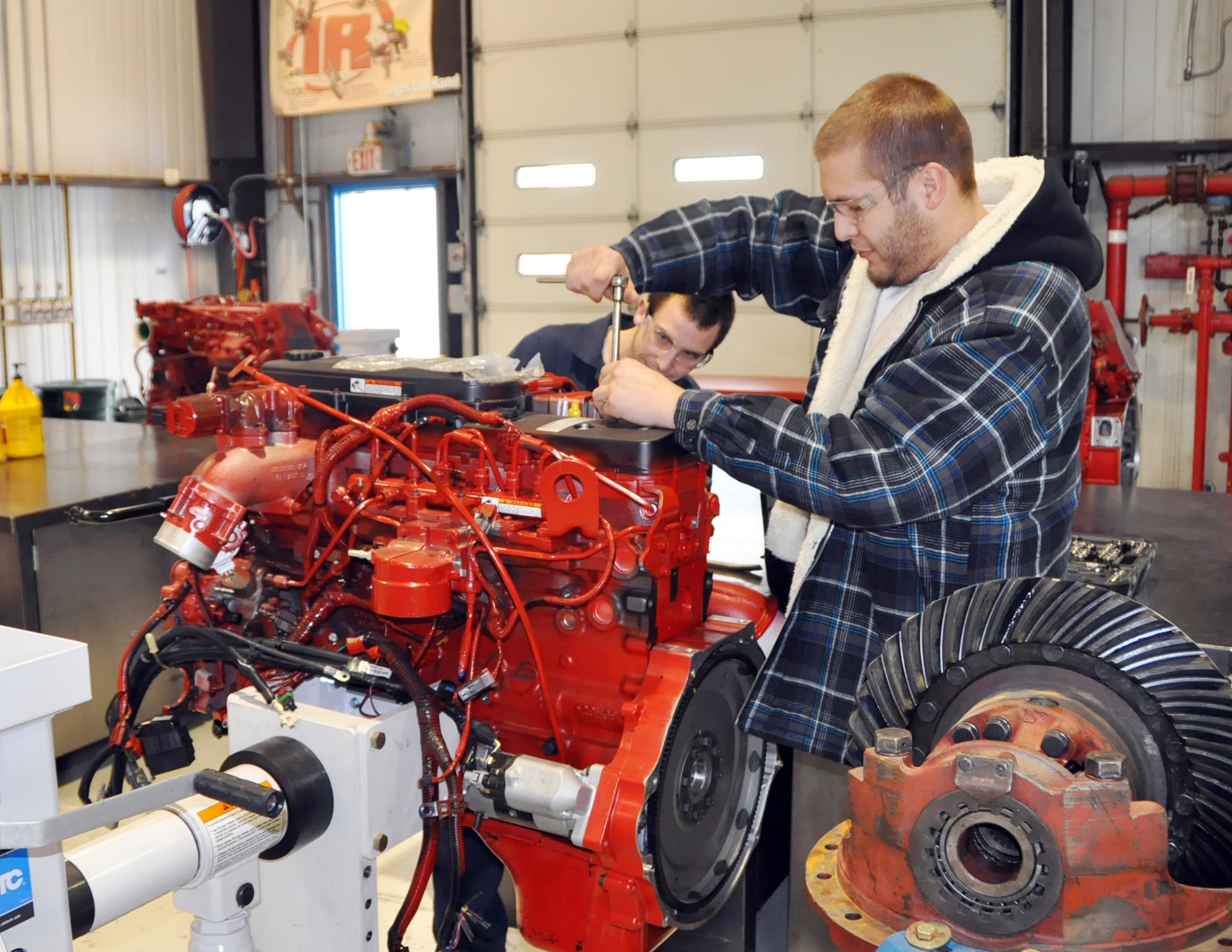 Todd Stretars (rear) and Martin Peck make adjustments to a diesel engine. Both students are enrolled in American River College's clean diesel technology program at the former Mather Air Force Base in Sacramento, Calif. (Courtesy photo)