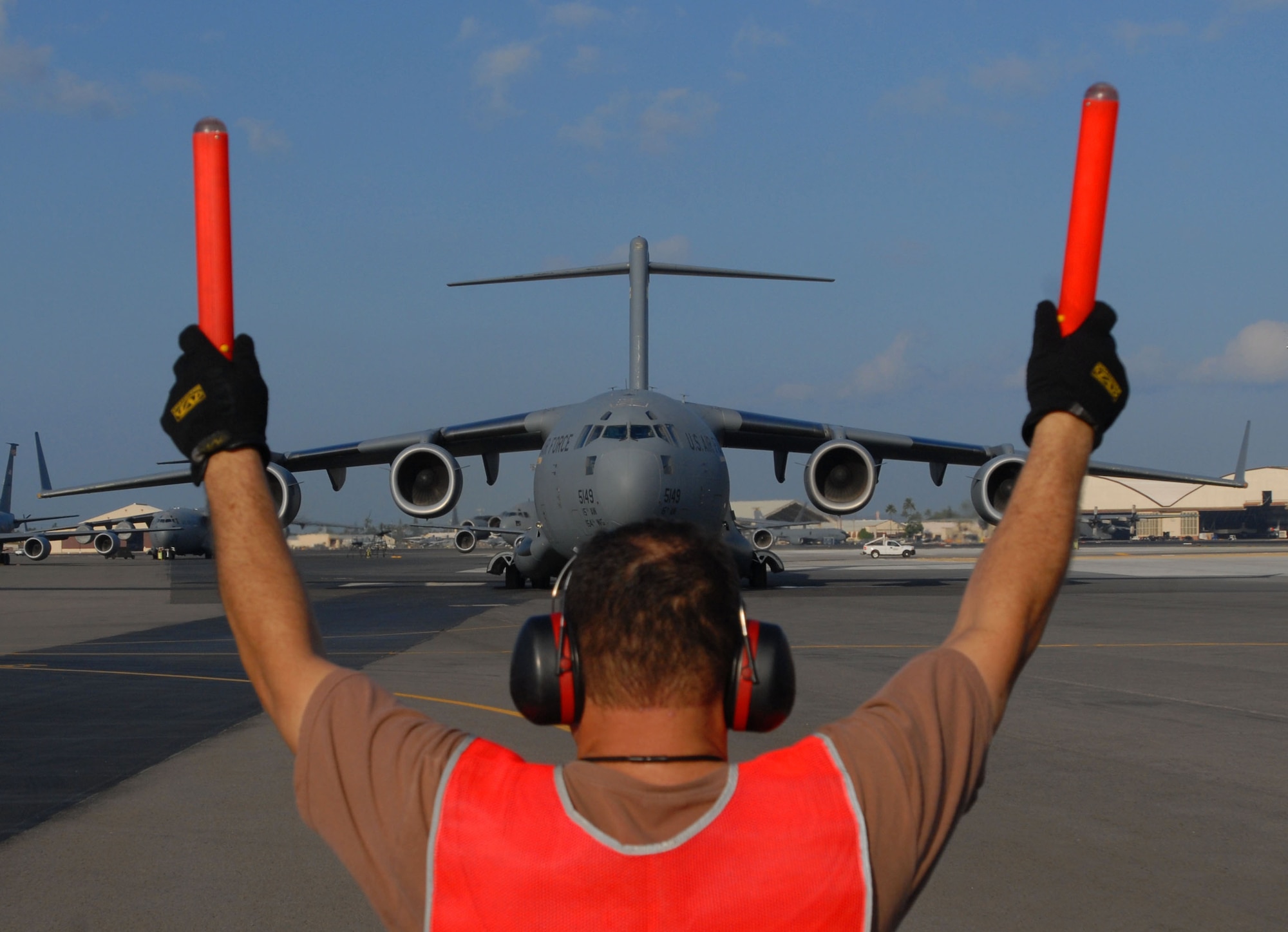 JOINT BASE PEARL HARBOR HICKAM, Hawaii - Staff Sgt. Jackie Grambusch, 154th Aircraft Maintenance Squadron, marshalls a C-17 Hickam Globmaster on its way to Thailand for exercise Cope Tiger here, Feb. 25. Cope Tiger is an annual exercise conducted in Asia-Pacific and includes humanitarioan and civic assistance program. Aviation and ground units from the U.S. Air Force, Republic of Singapore Air Force, and Royal Thai Air Force and Army will participate in the exercise from 1 Mar. through 12 Mar. (U.S. Air Force photo/Senior Airman Gustavo Gonzalez)