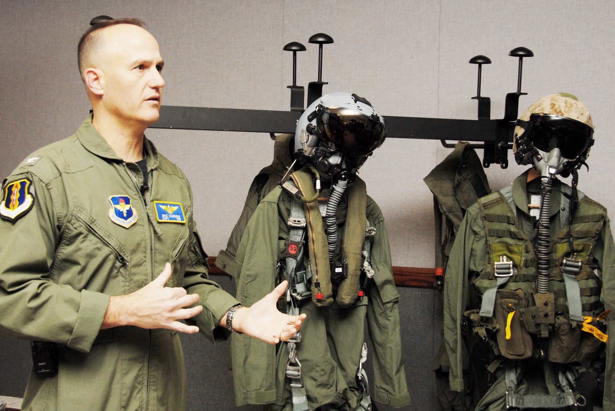 Navy Capt. Mike Saunders describes the F-35 Lightning II joint strike fighter pilot equipment after getting measured for the new suit Feb. 25, 2010, at Eglin Air Force Base, Fla. Captain Saunders is the 33rd Operations Group deputy commander. (U.S. Air Force photo/Airman 1st Class Anthony Jennings)