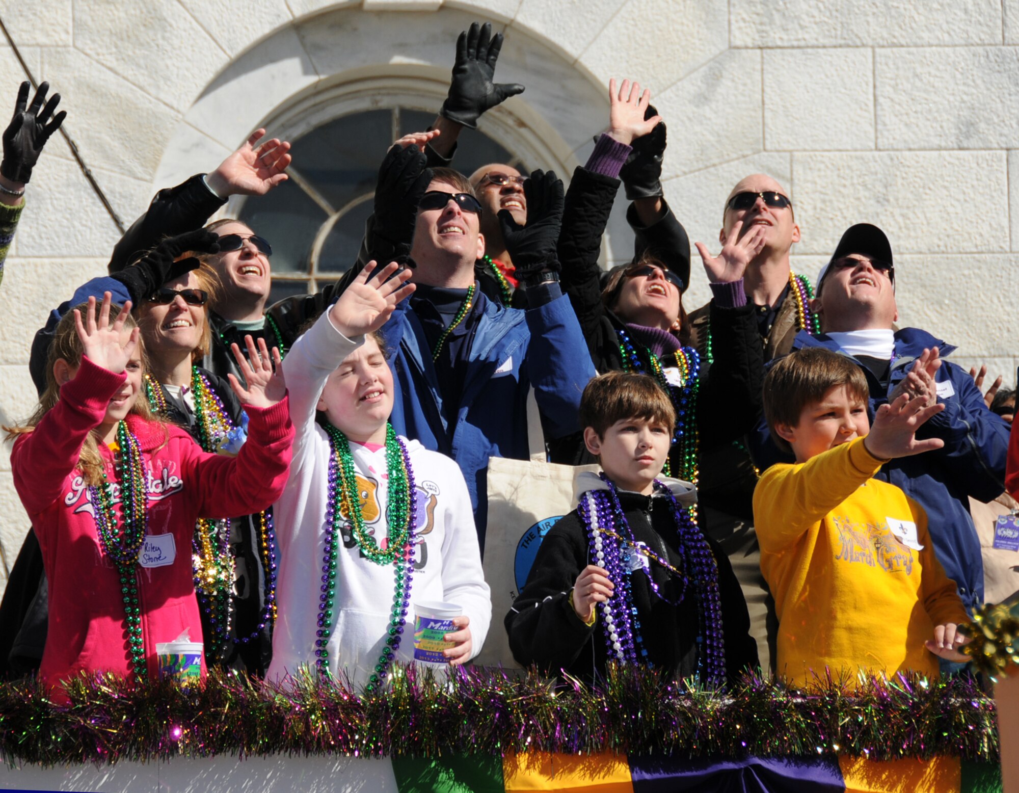 Keesler leaders and their family members reach for beads as floats pass the reviewing stand at the Gulf Coast Carnival Association Mardi Gras parade Feb. 16 in Biloxi.  (U.S. Air Force photo by Kemberly Groue)


