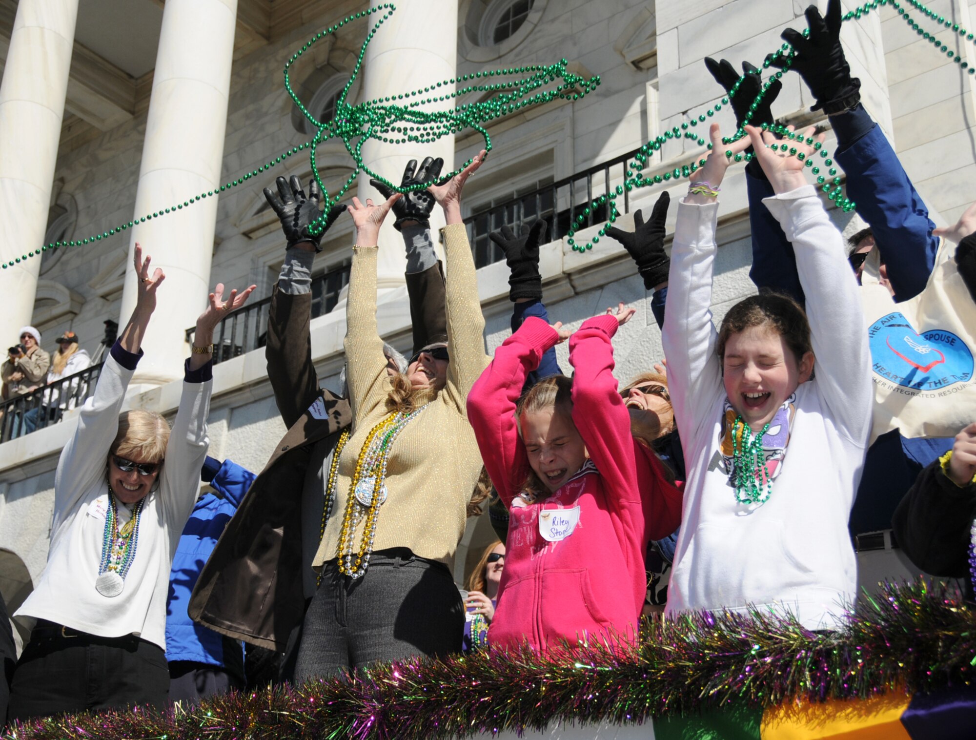 Keesler leaders and their family members reach for beads as floats pass the reviewing stand at the Gulf Coast Carnival Association Mardi Gras parade Feb. 16 in Biloxi.  (U.S. Air Force photo by Kemberly Groue)



