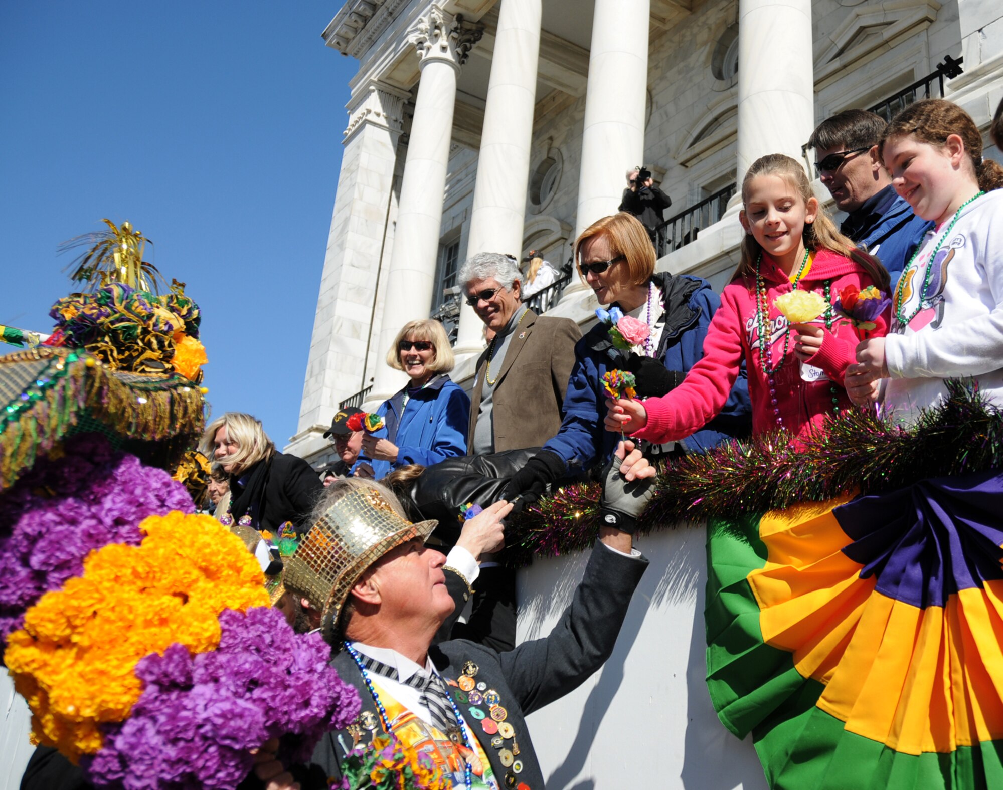 Keesler leaders and their family members accept crepe paper flowers from a member of the Ole Biloxi Marching Club at the Gulf Coast Carnival Association Mardi Gras parade Feb. 16 in Biloxi.  (U.S. Air Force photo by Kemberly Groue)


