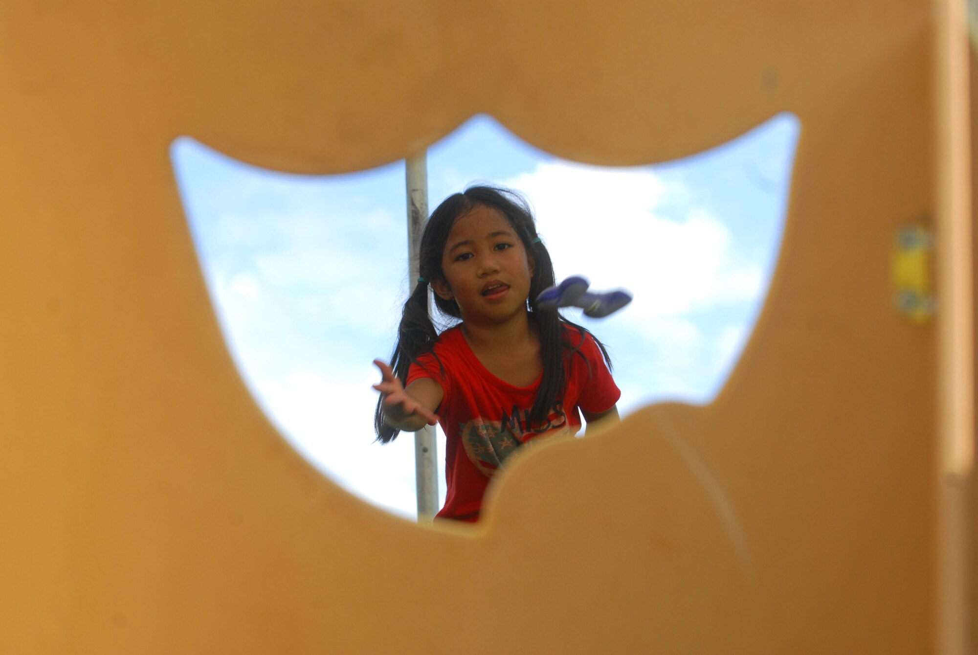 JOINT BASE PEARL HARBOR HICKAM, Hawaii - Kailani Balbas attempts to throw a bone through a hole at the bone toss game during Mahalo Fest here, Feb. 26. Mahalo Fest was hosted by the 15th Services Squadron marketing team in support of customer appreciation week. (U.S. Air Force photo/Senior Airman Gustavo Gonzalez)