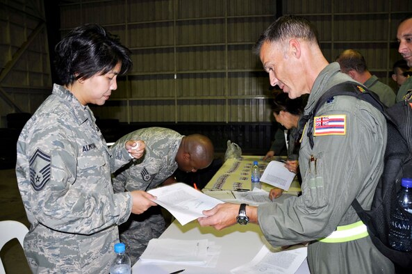 Senior Master Sgt. Merian Almosara collects a copy of deployment orders from Lt. Col. Gregory Woodrow at Udon Thani Royal Thai Air Force Base, Thailand, on Feb. 26.  Sergeant Almosara, an Air Force reservist stationed at Joint Base Pearl Harbor Hickam, Hawaii, and Colonel Woodrow, a guardsman also from JB Pearl Harbor Hickam, are among 500 total force Airmen in Thailand to participate in Cope Tiger 2010 March 1-12.  They will join servicemembers from the Royal Thai Air Force and Army, and the Republic of Singapore Air Force for the multilateral exercise. (U.S. Air Force photo/Capt. Christy Stravolo)