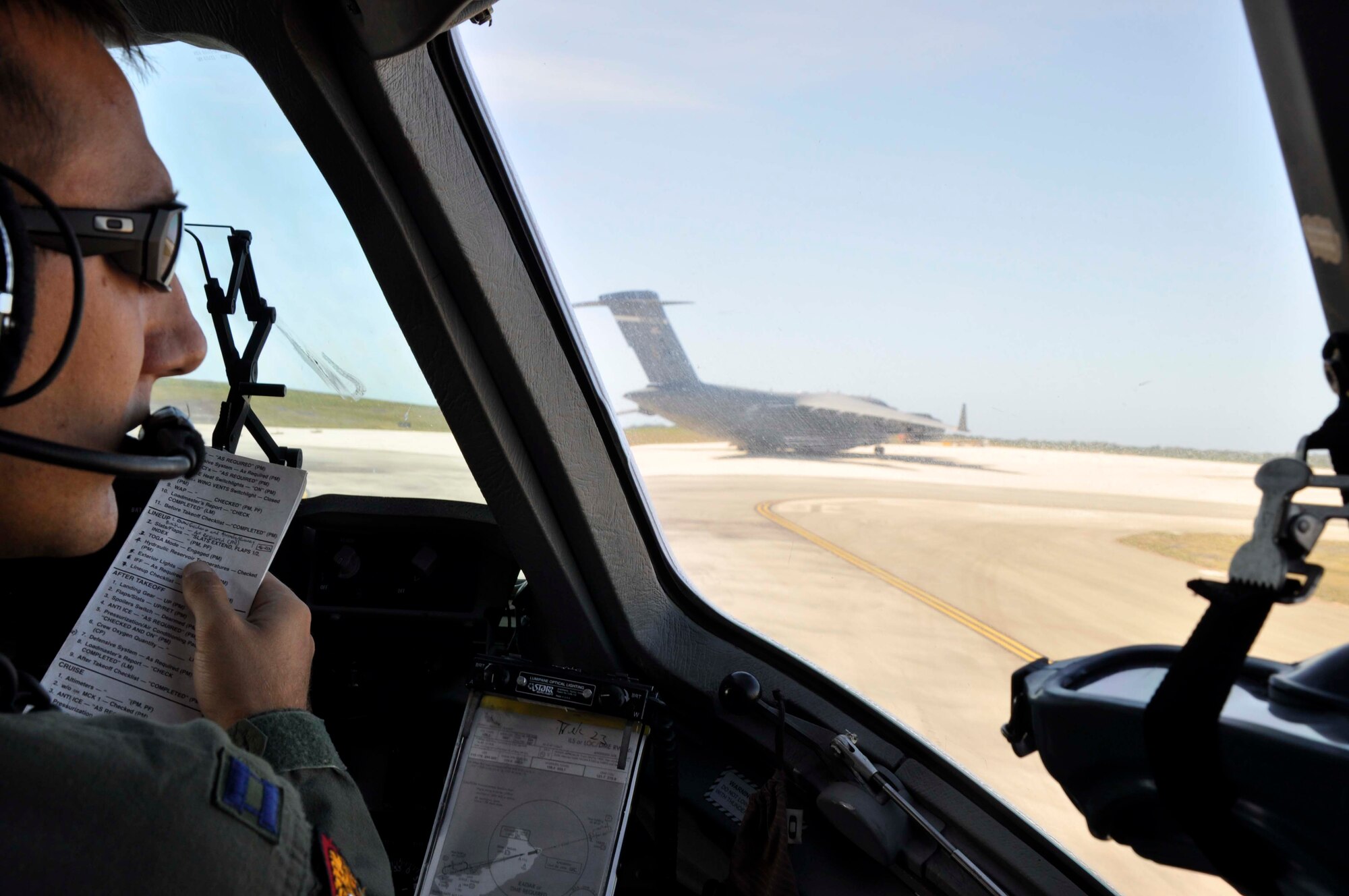 Capt. Nate Padgett runs through some final checklist items as his C-17 Globemaster III taxis behind another C-17 at Joint Base Pearl Harbor Hickam, Hawaii, on Feb. 25.  Both aircraft flew in a two-ship formation from Hawaii to Thailand.  There they will participate in Cope Tiger 2010, an annual, multilateral field training exercise involving the U.S. Air Force, Royal Thai Air Force and Army, and the Republic of Singapore Air Force March 1-12.  Captain Padgett is from the 535th Airlift Squadron at JB Pearl Harbor Hickam.  (U.S. Air Force photo/Capt. Christy Stravolo)
