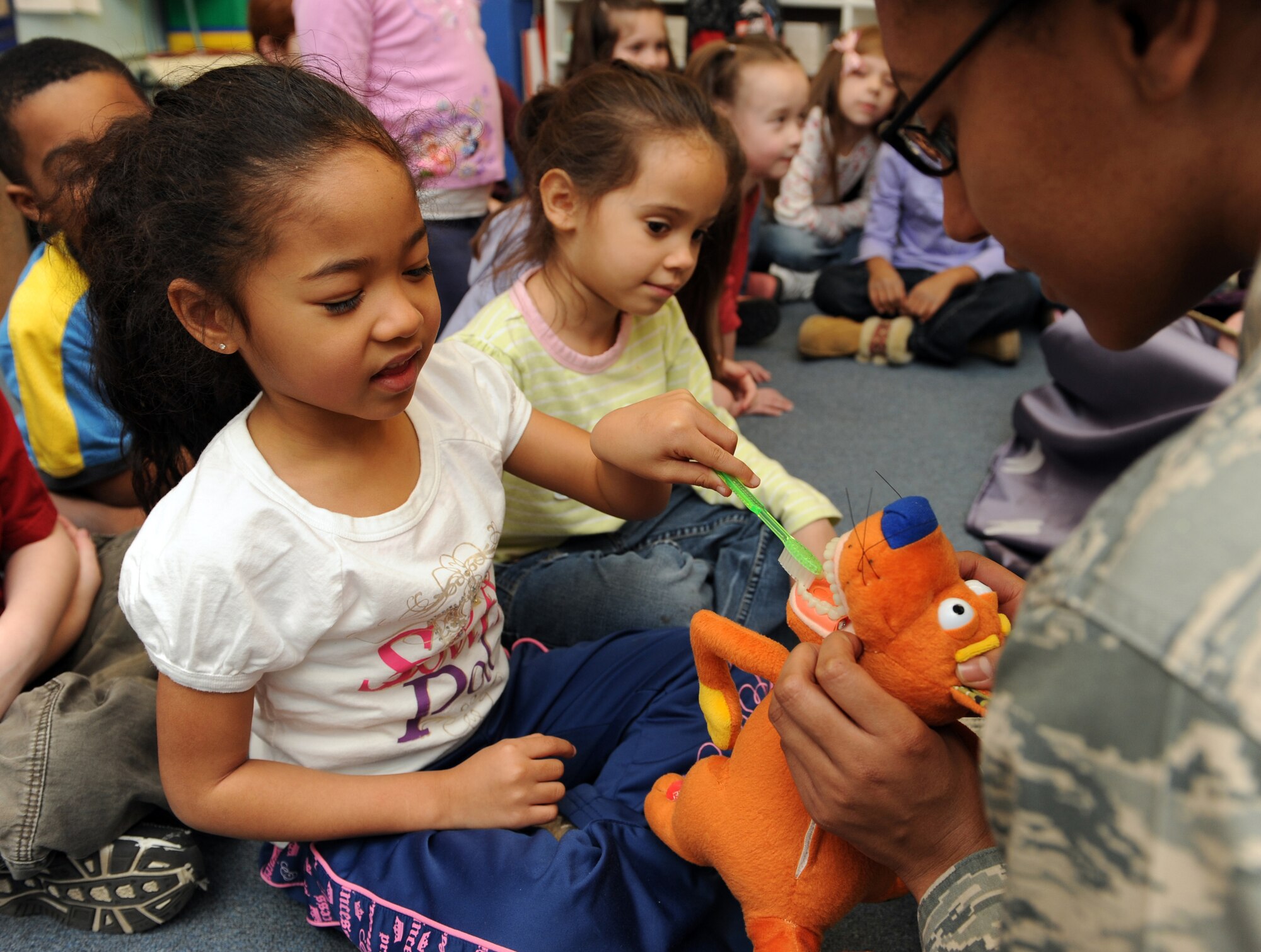 MOUNTAIN HOME AIR FORCE BASE, Idaho -- Airman 1st Class Harlandria Moses, 366th Dental Squadron dental assistant, teaches Mijun Heard, a student in Mrs. Pelkey's kindergarten class, how to floss during a visit to the base primary school Feb. 25. The dental squadron visited the school to teach children from kindergarten to fourth grade the importance of dental health for Children's Dental Health month celebrated every February. (U.S. Air Force photo by Airman 1st Class Debbie Lockhart)