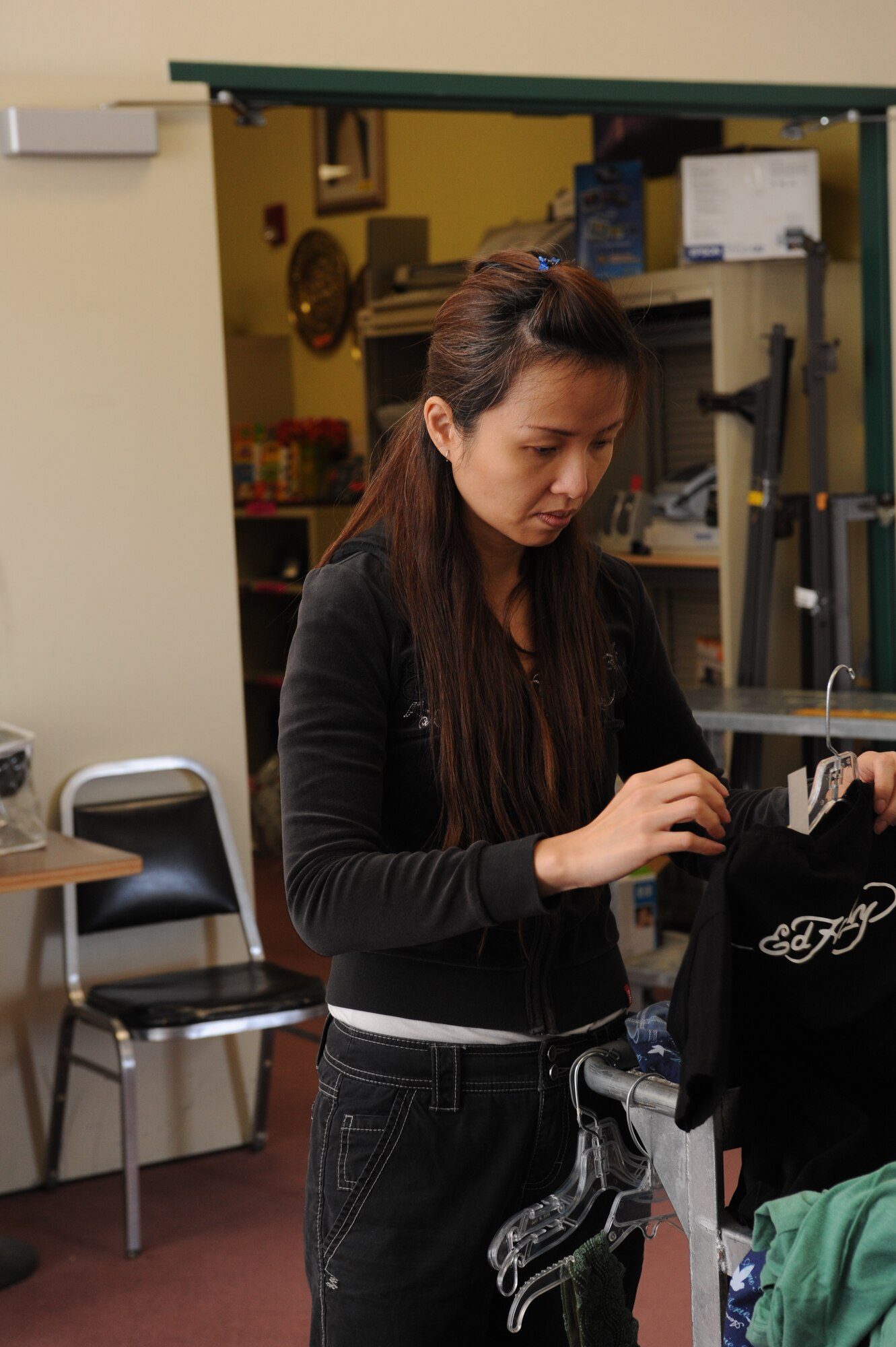 MOUNTAIN HOME AIR FORCE BASE, Idaho – Michelle Toh, wife of 428th Fighter Squadron 2WO Jansen Woo, organizes clothes to be put on sale of the Mountain Home AFB Thrift Shop. The Thrift Shop helps raise money for scholarships offered to Gunfighter spouses and children. (U.S. Air Force photo by 1st Lt. Neil Samson)
